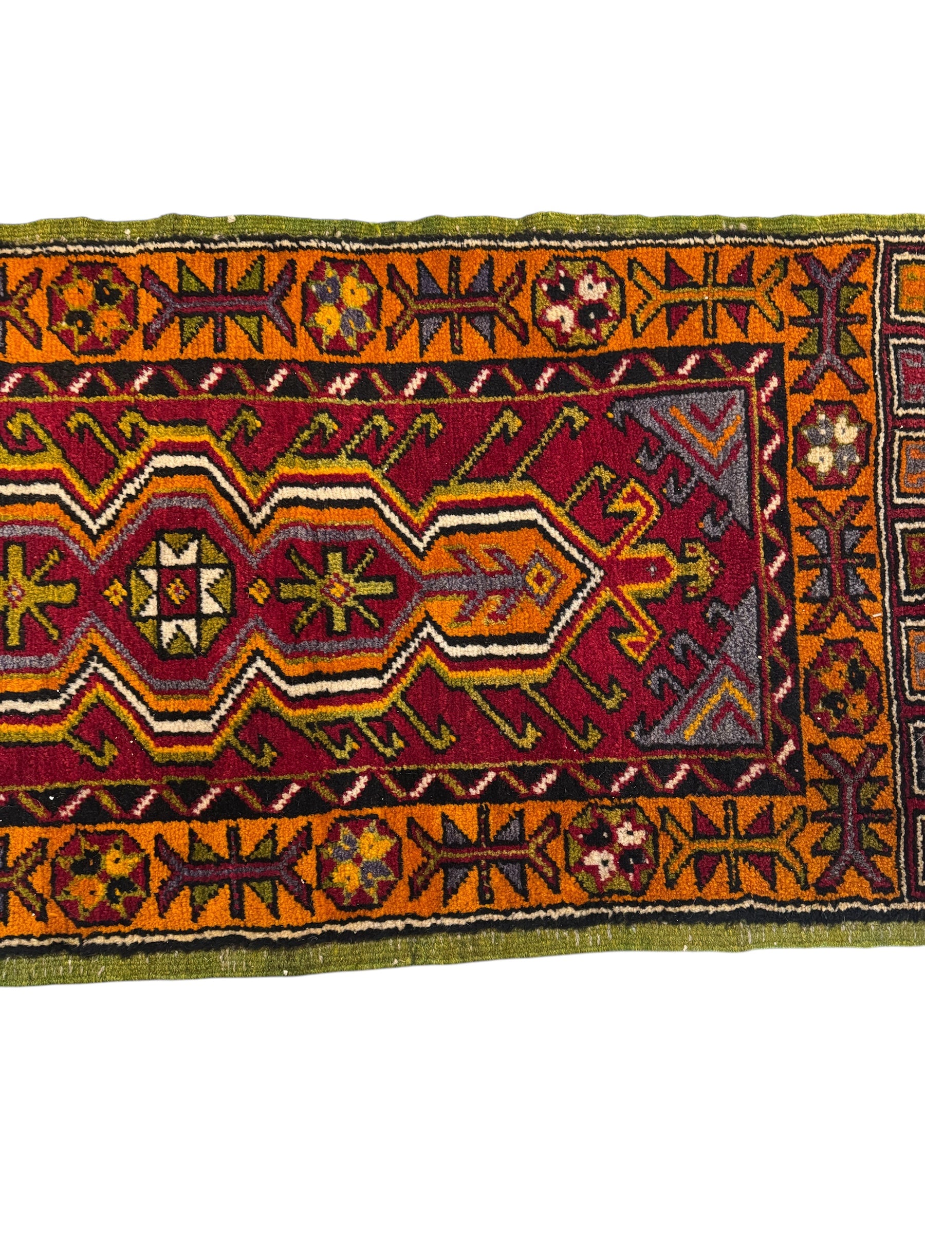 Anatolian Yastik rug with red, gold, green and gray geometric patterns and fringe.