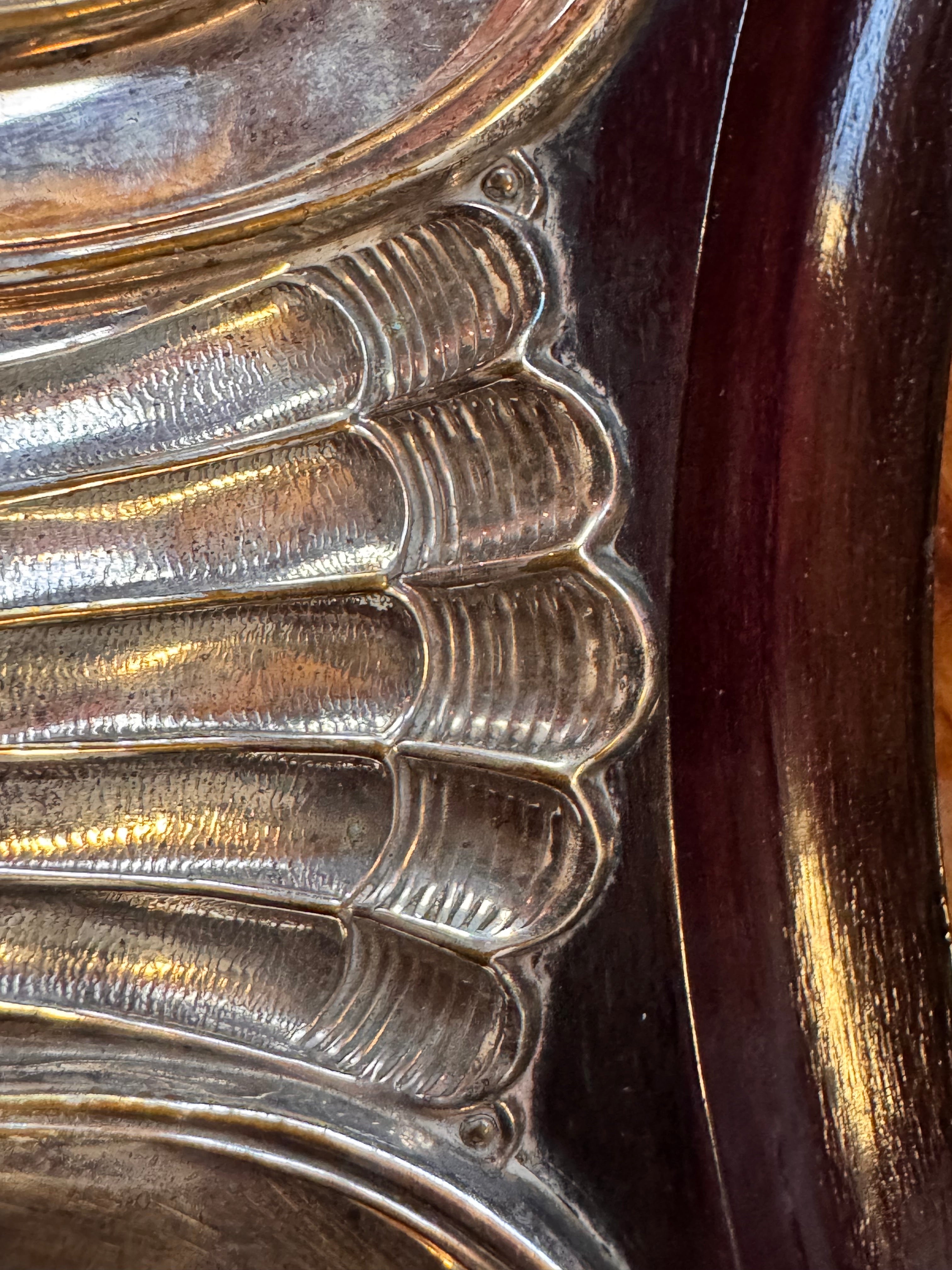 An ornate Art Deco serving tray featuring a highly figured burlwood center and silver-plated handles and rim