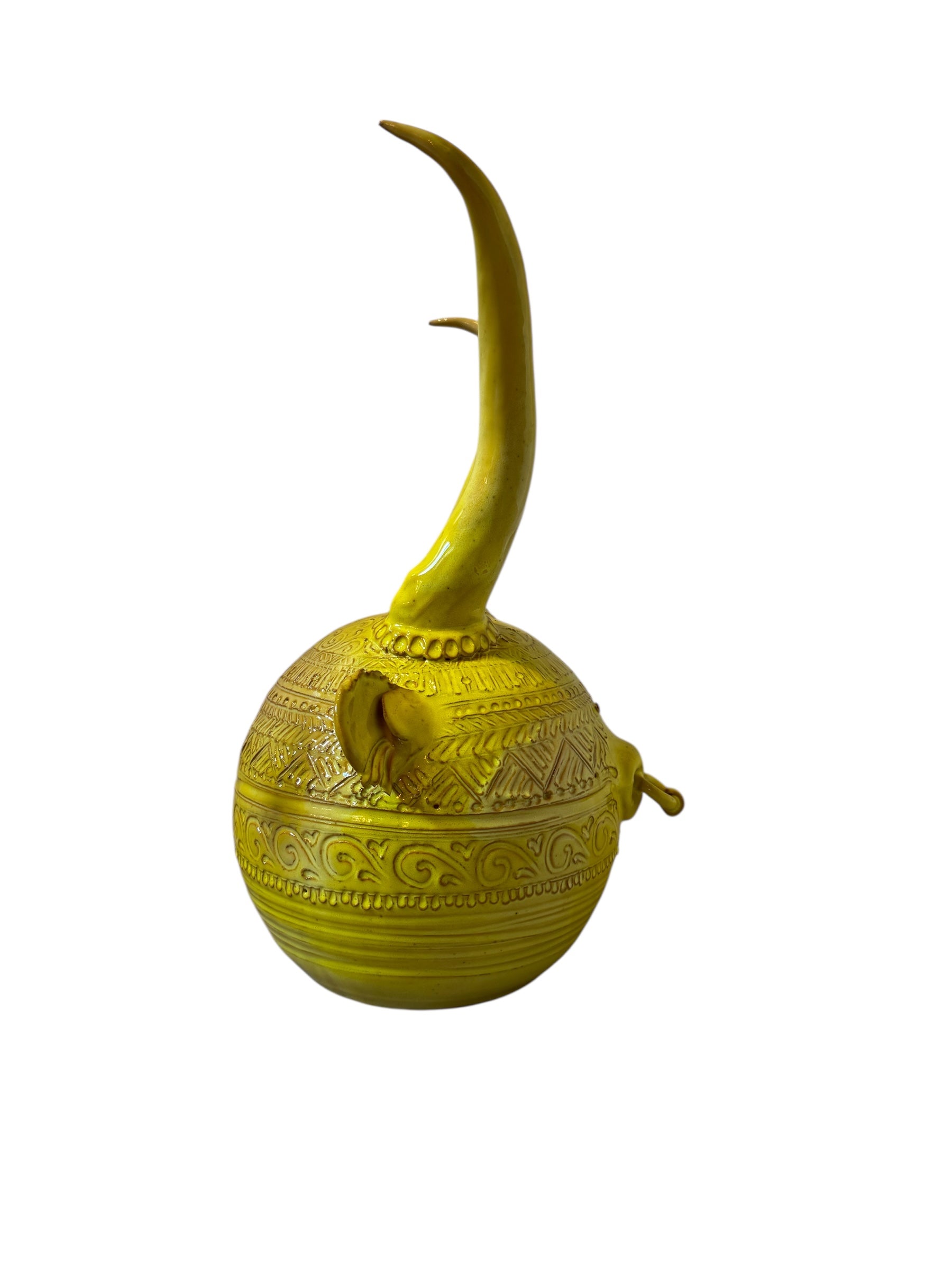 Yellow ceramic sculpture titled 'The Ram Oracle' by Enza Fasano, featuring a round body with intricate, hand-incised patterns and long, stylized ram-like horns