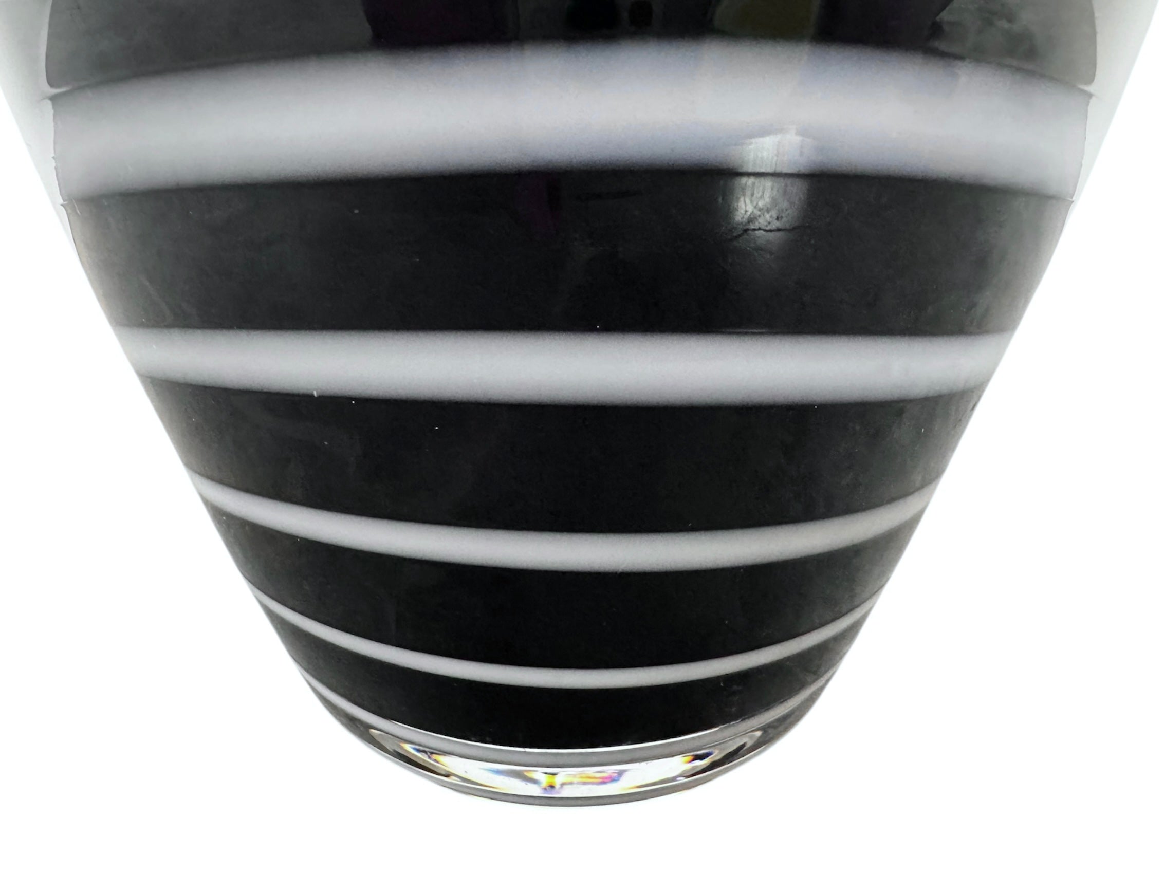 A sleek, hand-blown Polish art glass vase featuring a tall, slender neck that flares into a rounded, bulbous body. The vase is made of opaque black glass decorated with a continuous white spiral ribbon that winds around the entire piece from base to rim. The high-gloss, reflective surface creates sharp highlights, emphasizing its smooth, sculptural silhouette against a plain white background.