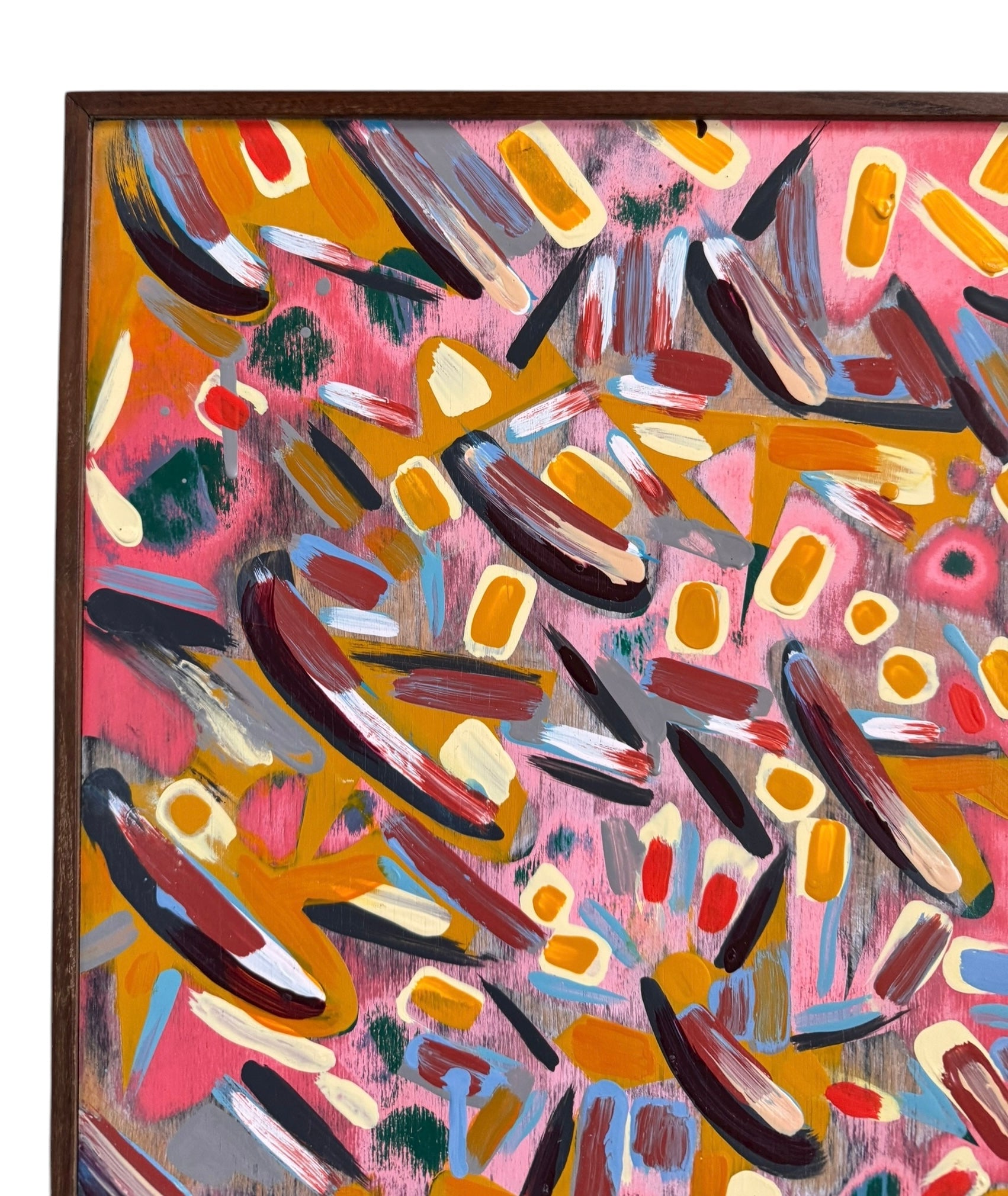 An abstract painting titled 'Cascade of Gold and Pink' by Robert Wymer, framed in dark wood. The artwork features a vibrant pink background densely covered with a dynamic arrangement of multi-directional, oblong, and dash-like brushstrokes in gold, red, blue, gray, white, and black.