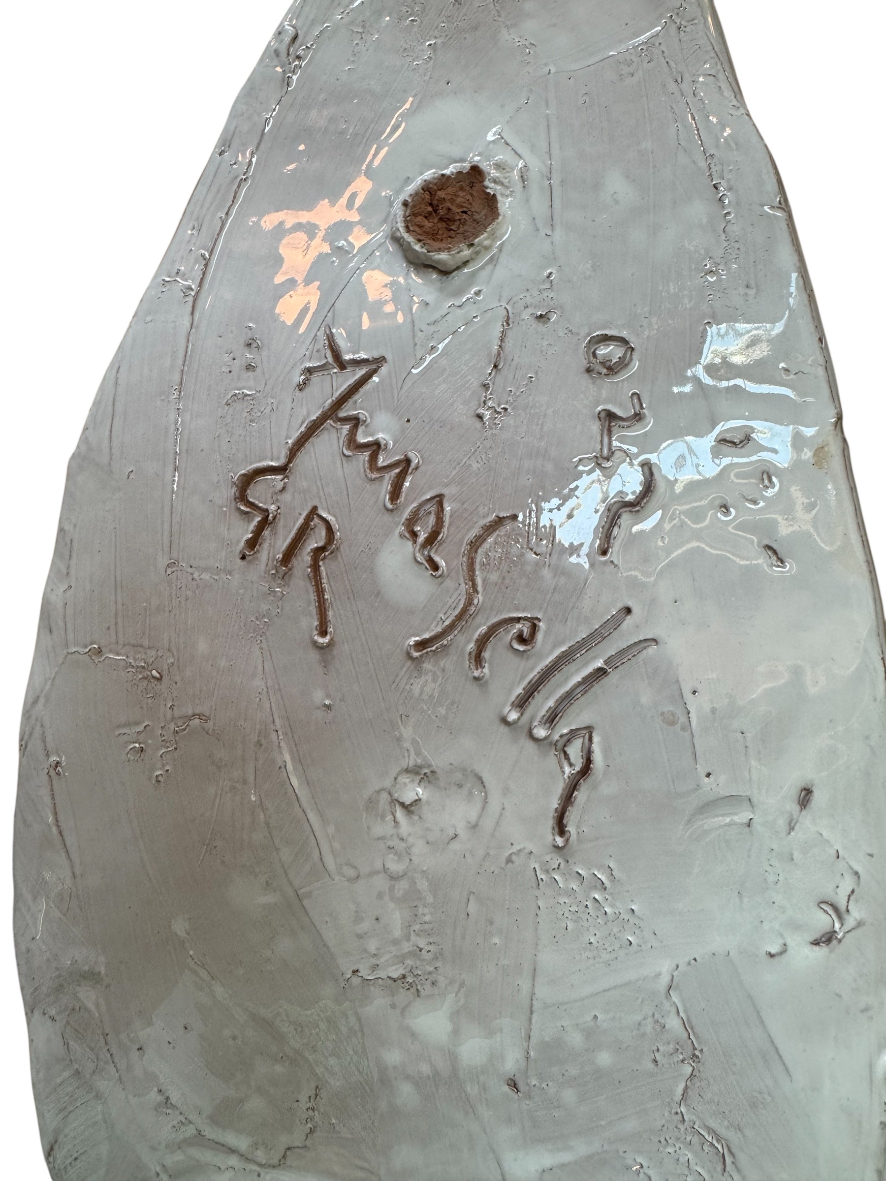 A white and green, glazed ceramic platter in the shape of a prickly pear cactus pad with attached prickly pear fruit. The surface has raised dots representing spines.