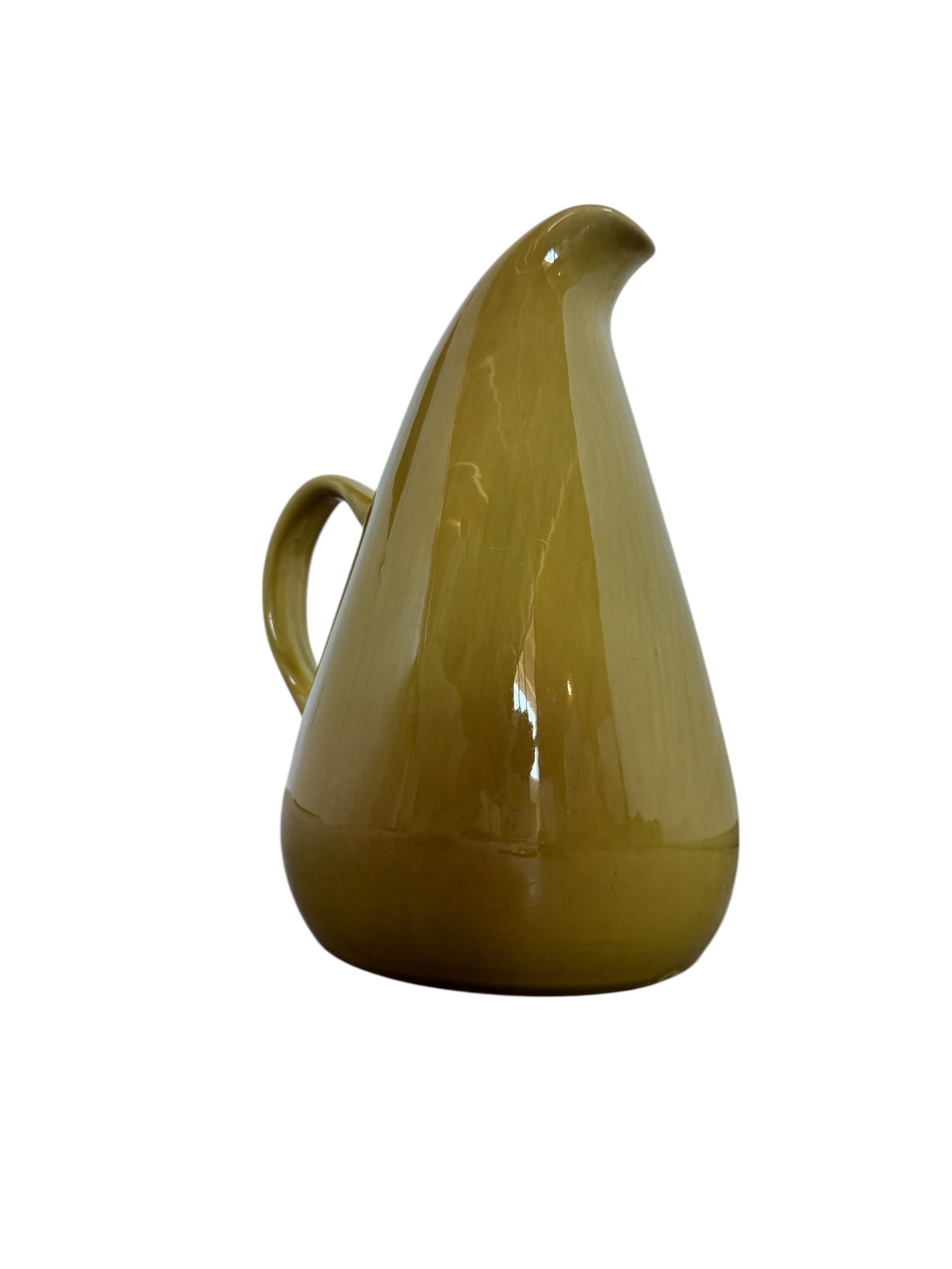 A chartreuse (yellow-green) ceramic pitcher designed by Russel Wright, featuring a teardrop shape, an elongated spout, and a curved handle