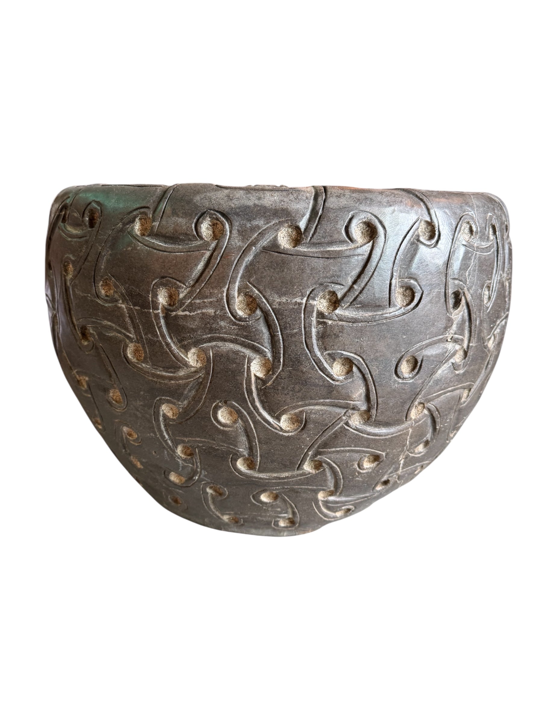 A heavy stone planter, featuring an intricate, hand-carved pattern resembling Celtic knot work.