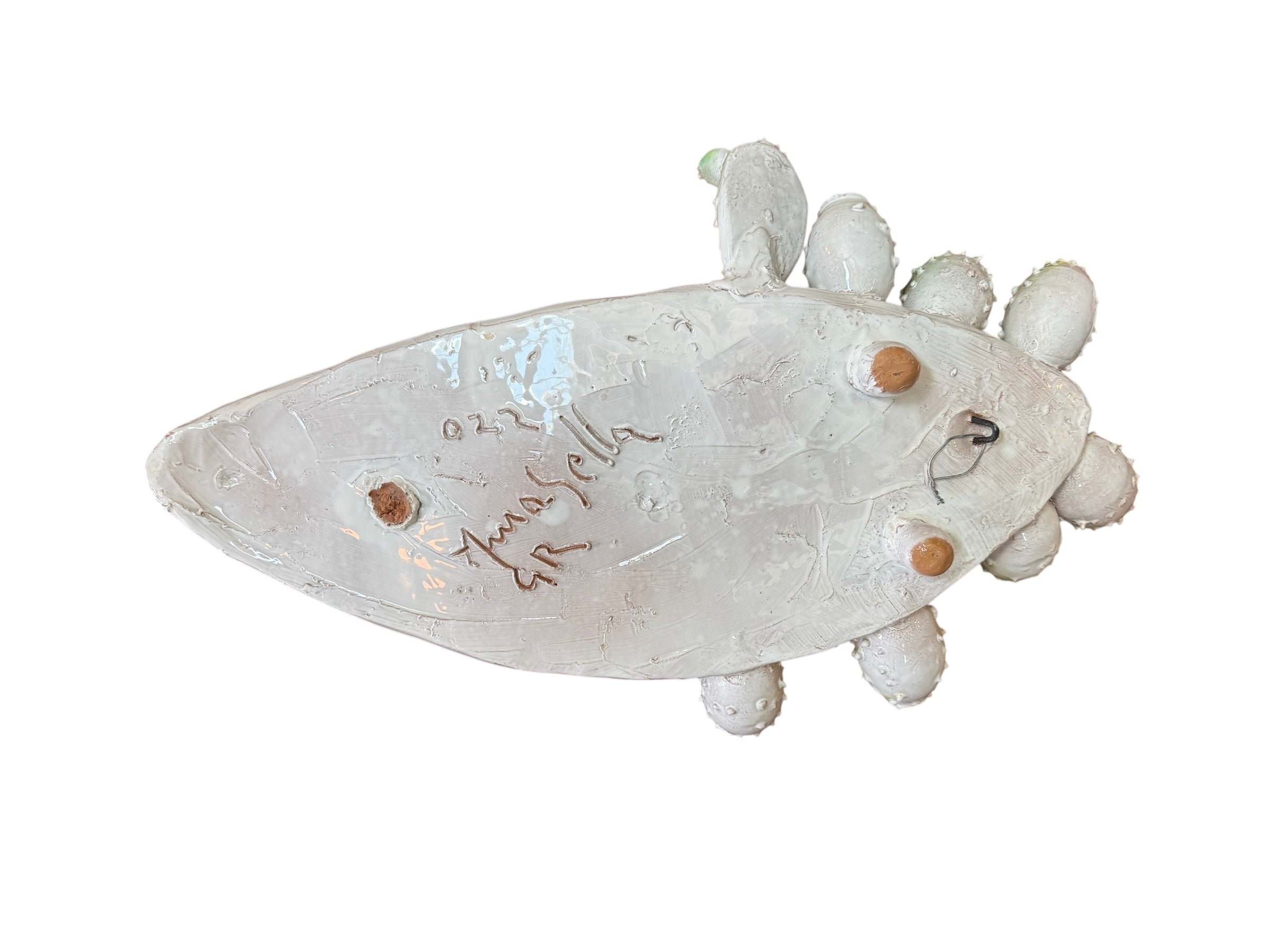 A white and green, glazed ceramic platter in the shape of a prickly pear cactus pad with attached prickly pear fruit. The surface has raised dots representing spines.