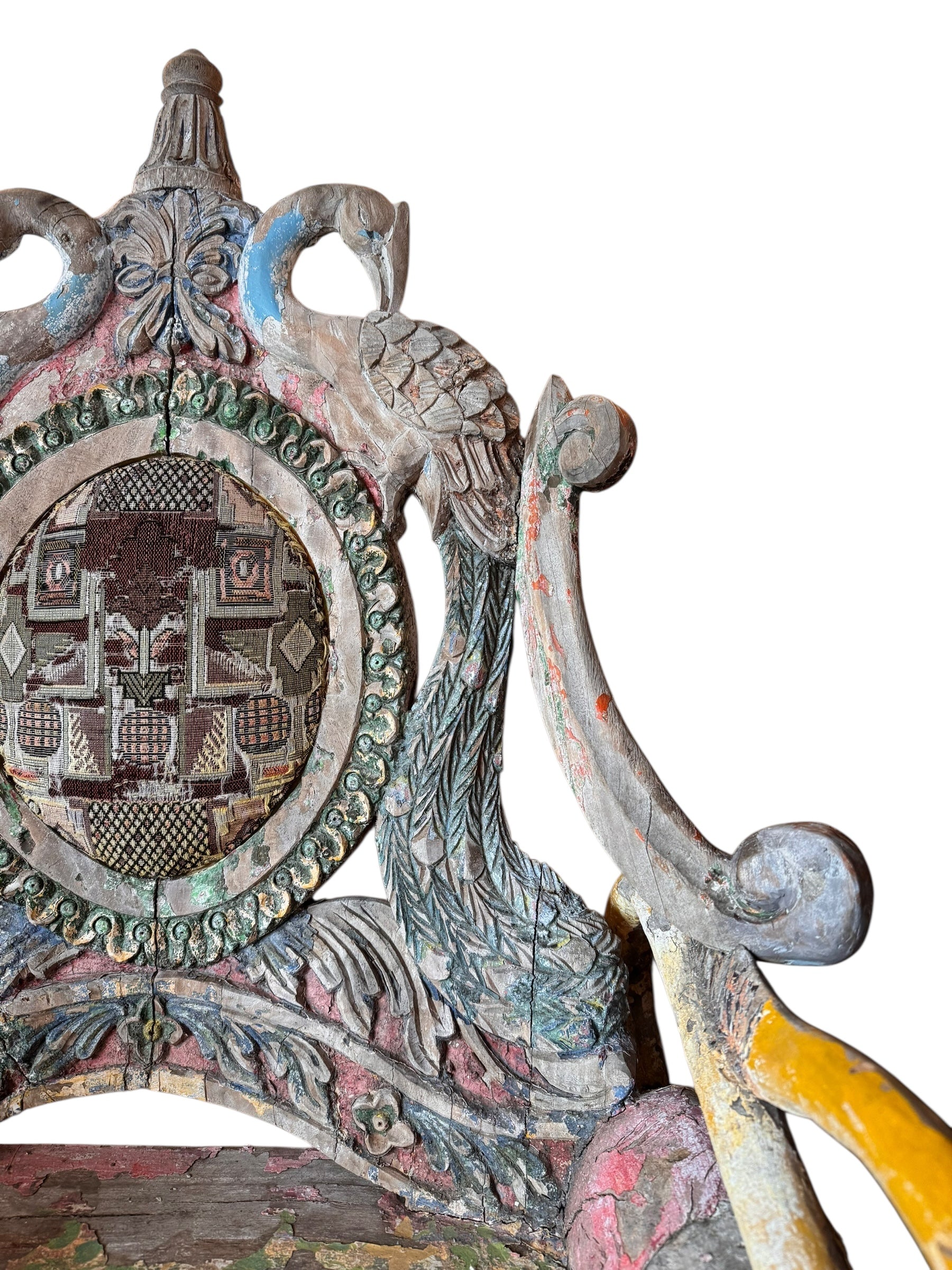 A pair of antique, heavily carved Anglo-Indian style throne chairs featuring lion figures as legs and arm supports, and peacock motifs on the backrests. The chairs have a distressed, multi-colored painted finish.