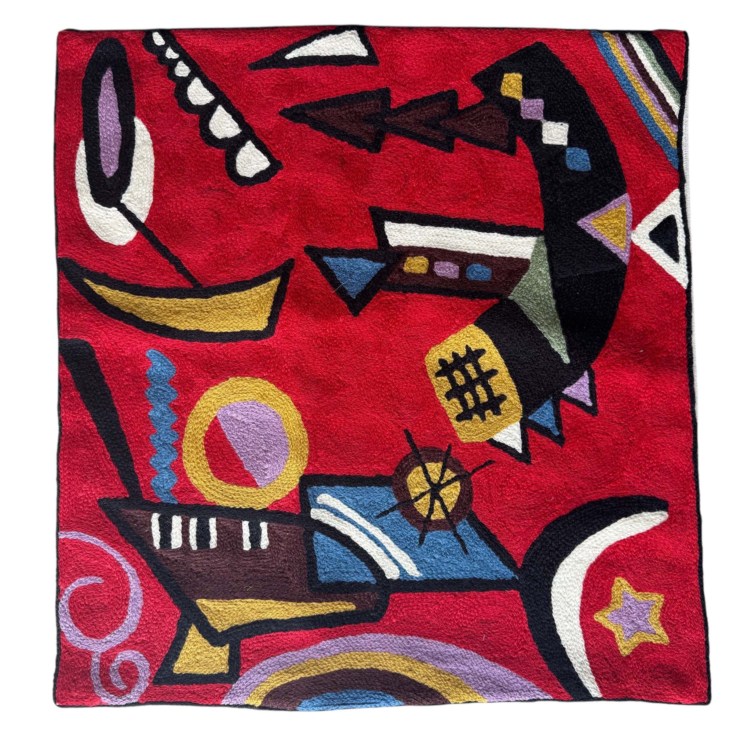 Abstract pattern. Red background. Vibrant cross-stitched pillows from India with various artistic designs, sourced in Aix-en-Provence.