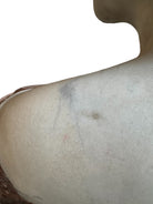 A 25-inch high polychrome marble bust of a woman, featuring white marble for her face and hair, with a base and draped fabric adorned with carved roses and leaves.