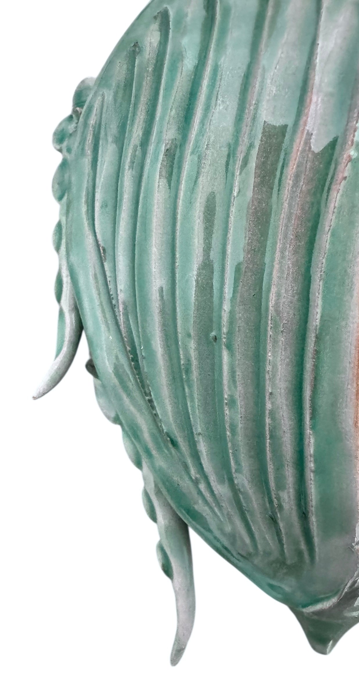 A ceramic sculpture of a stylized beetle by Enza Fasano, featuring a deep emerald green glaze with dark, metallic bronze-colored accents. The beetle is depicted with a highly textured, ribbed shell (elytra) and prominent, curved horns. Its legs are stylized with suckers, reminiscent of octopus tentacles. The piece has a glossy finish and rests against a plain white background.