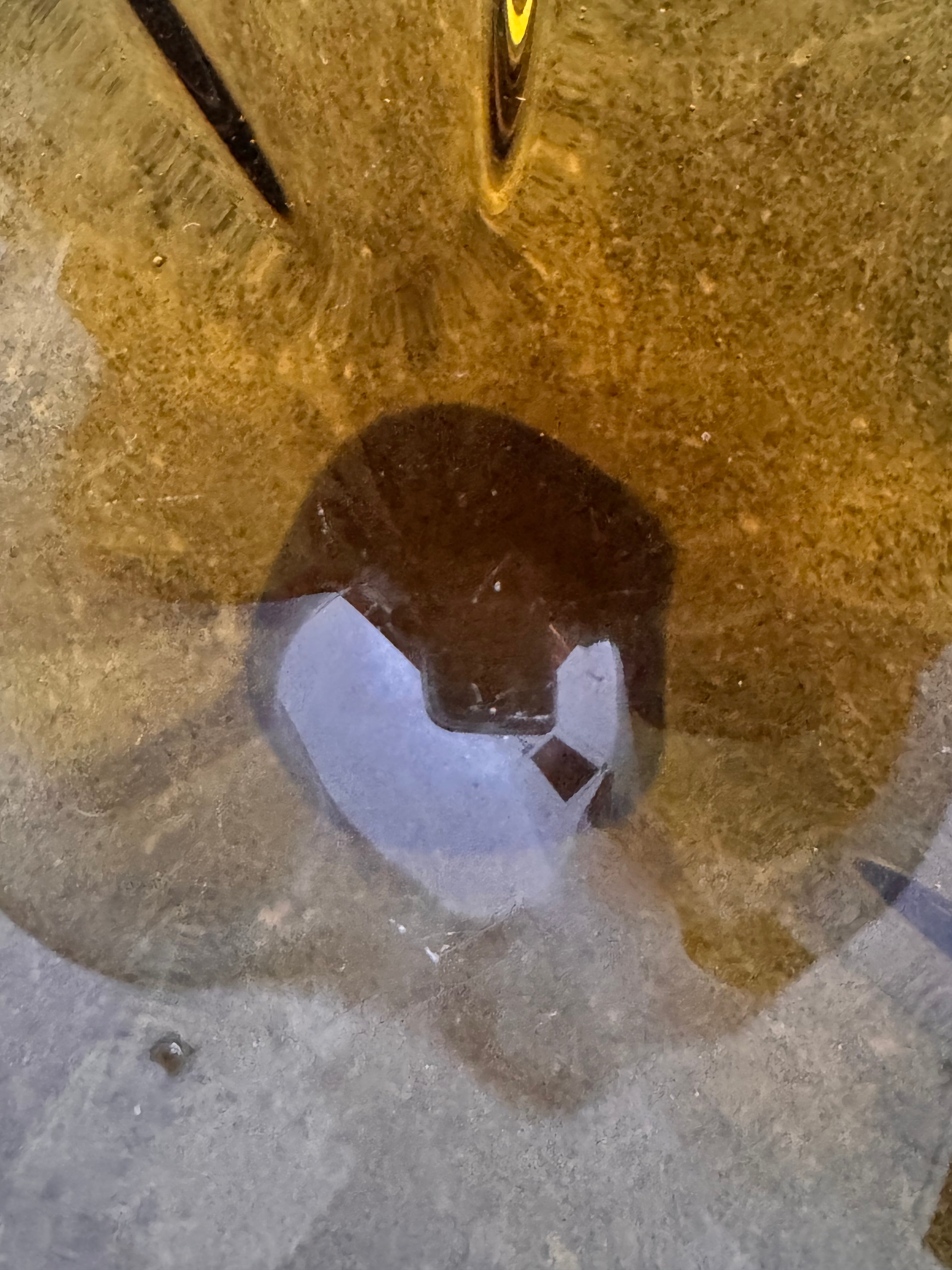 A vintage, hand-blown art glass bowl with a wavy, organic shape and a blue and amber/yellow swirl design