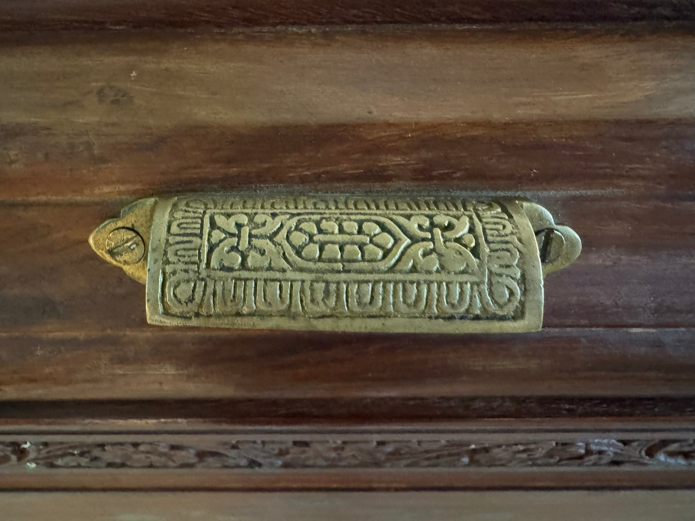 Antique bar cabinet with wood inlay and brass floral details, open to reveal interior shelving and bar storage