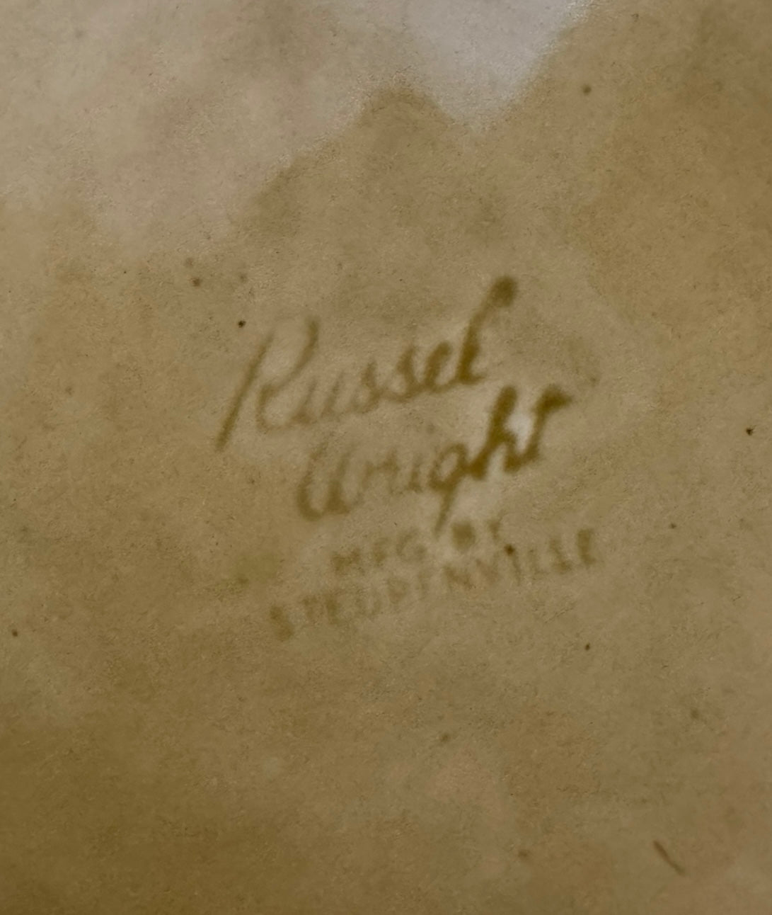 A chartreuse (yellow-green) ceramic pitcher designed by Russel Wright, featuring a teardrop shape, an elongated spout, and a curved handle