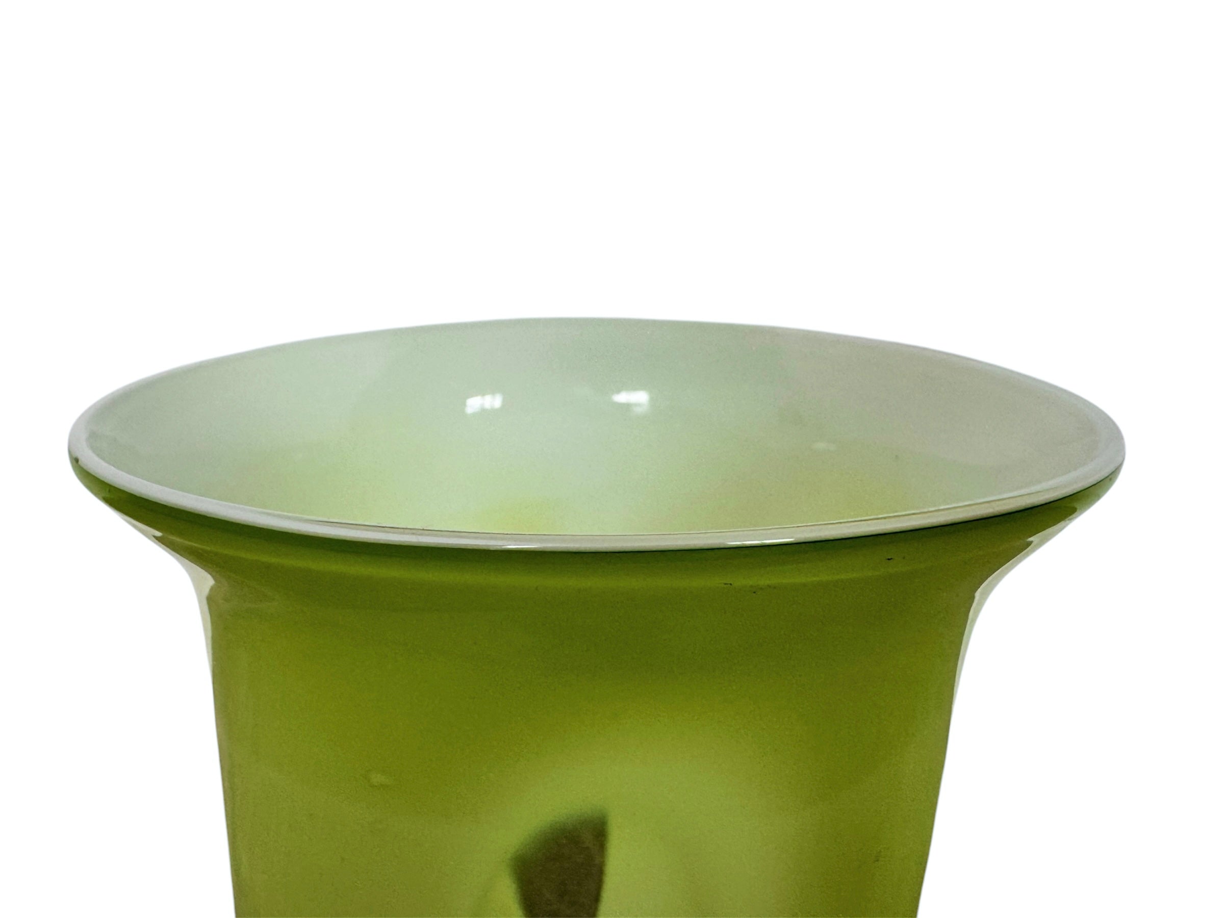 A mid-century modern, lime green cased-glass vase with a wide, flared rim and a thick, clear glass base. The exterior is a glossy chartreuse green, while the interior is lined with solid milk-white glass. The defining feature is a large, vertical oval cutout window that pierces directly through the center of the vase's body, creating an open-air negative space.