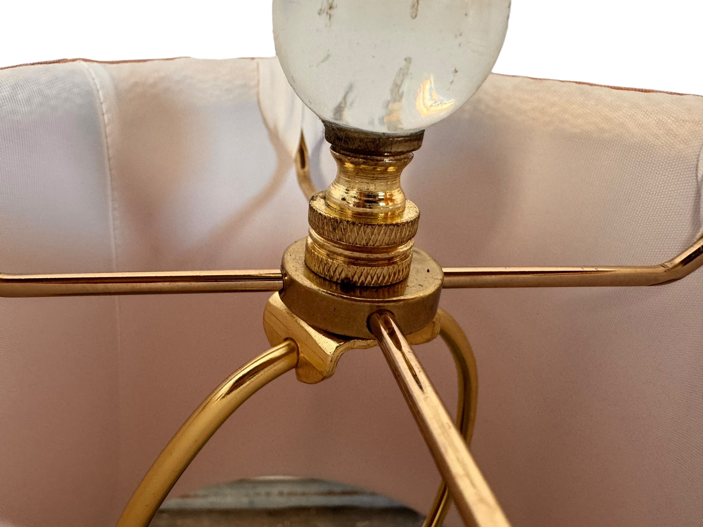 A table lamp featuring a teardrop-shaped, reddish-purple glass base and a conical, pleated, light-pink fabric shade.