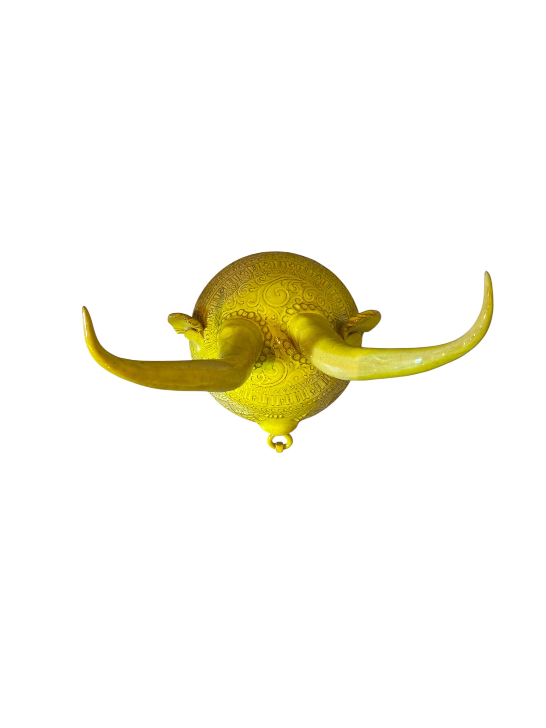 Yellow ceramic sculpture titled 'The Ram Oracle' by Enza Fasano, featuring a round body with intricate, hand-incised patterns and long, stylized ram-like horns