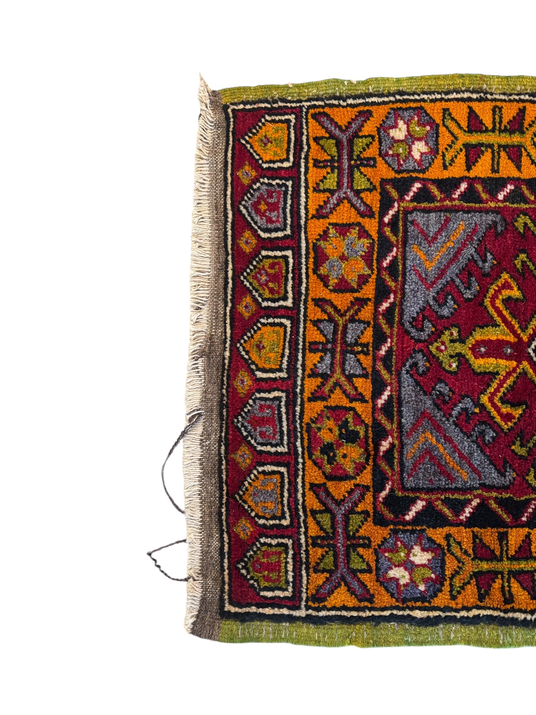 Anatolian Yastik rug with red, gold, green and gray geometric patterns and fringe.