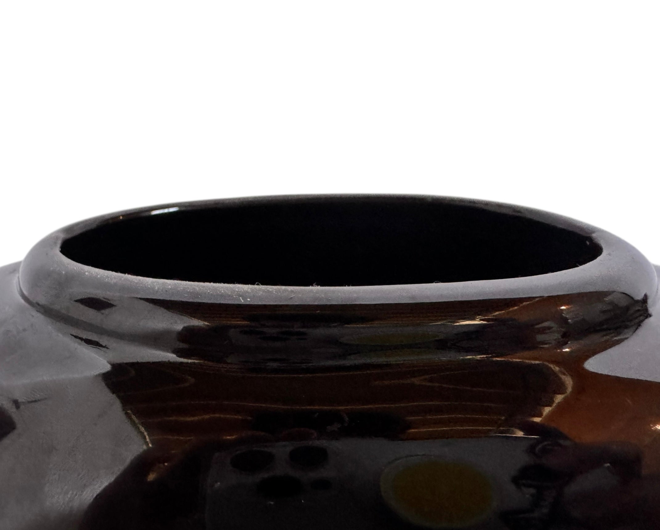 A round, glossy black vase with a small opening.
The vase has a spherical or gourd-like shape and a highly reflective, black glazed finish.