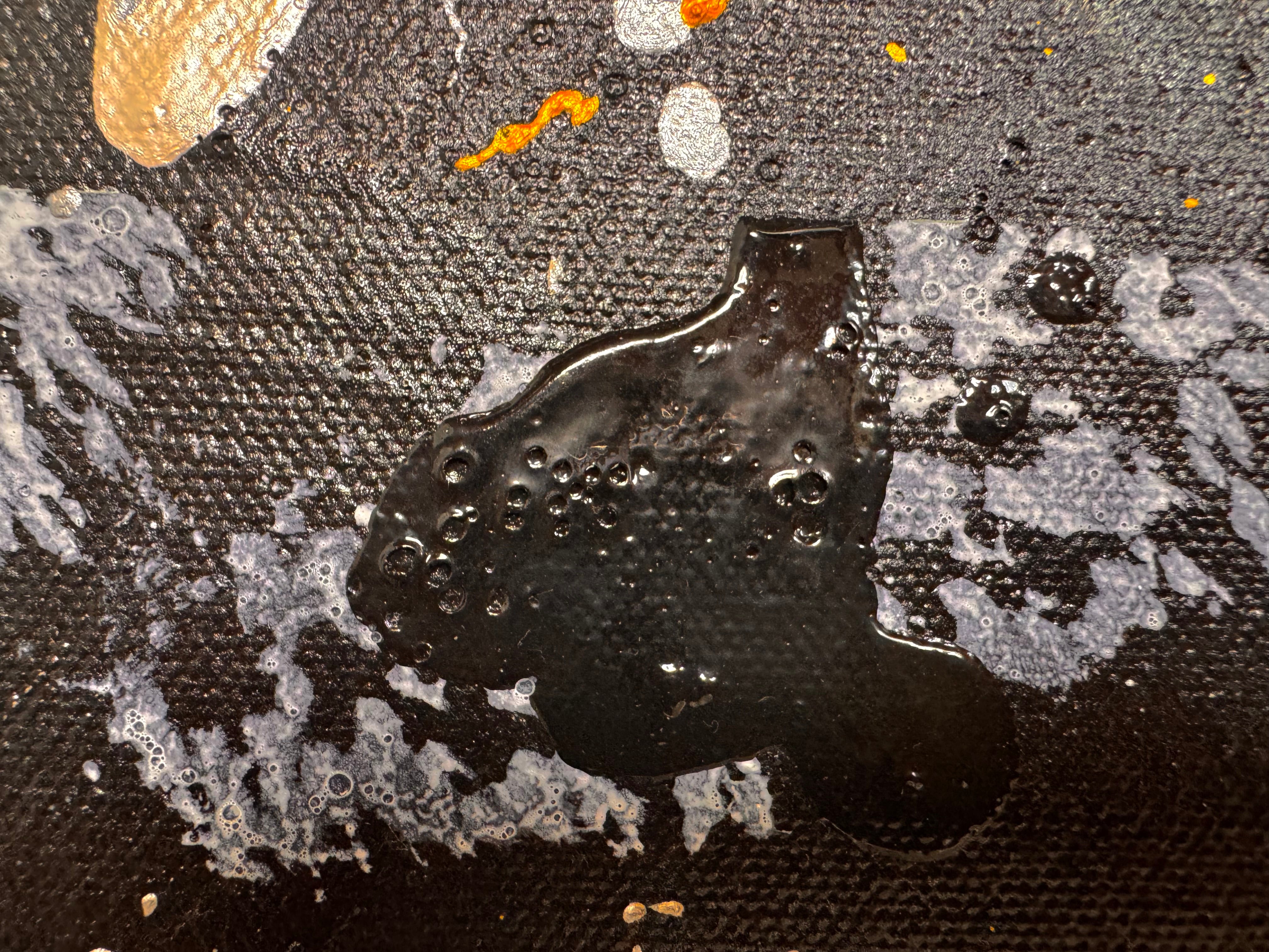 An abstract, vertical-oriented canvas painting featuring a dark background layered with highly textured, horizontal bands. The composition alternates between solid black strips and dense, speckled white-and-grey patterns that resemble static or stone texture. Splattered across the surface are energetic drips, lines, and splotches of bright yellow, stark white, and grey paint, creating a chaotic yet rhythmic sense of movement overlaying the geometric structure underneath.
