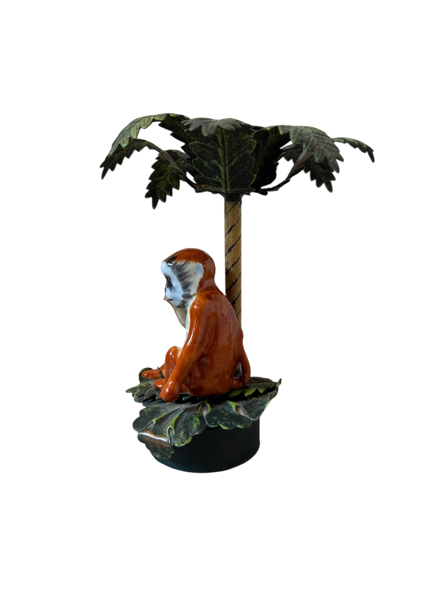 Three toleware candlesticks by Petite Choses, each featuring a metal palm tree with painted details and a porcelain monkey figure attached by wire. The candlesticks have a circular iron base.