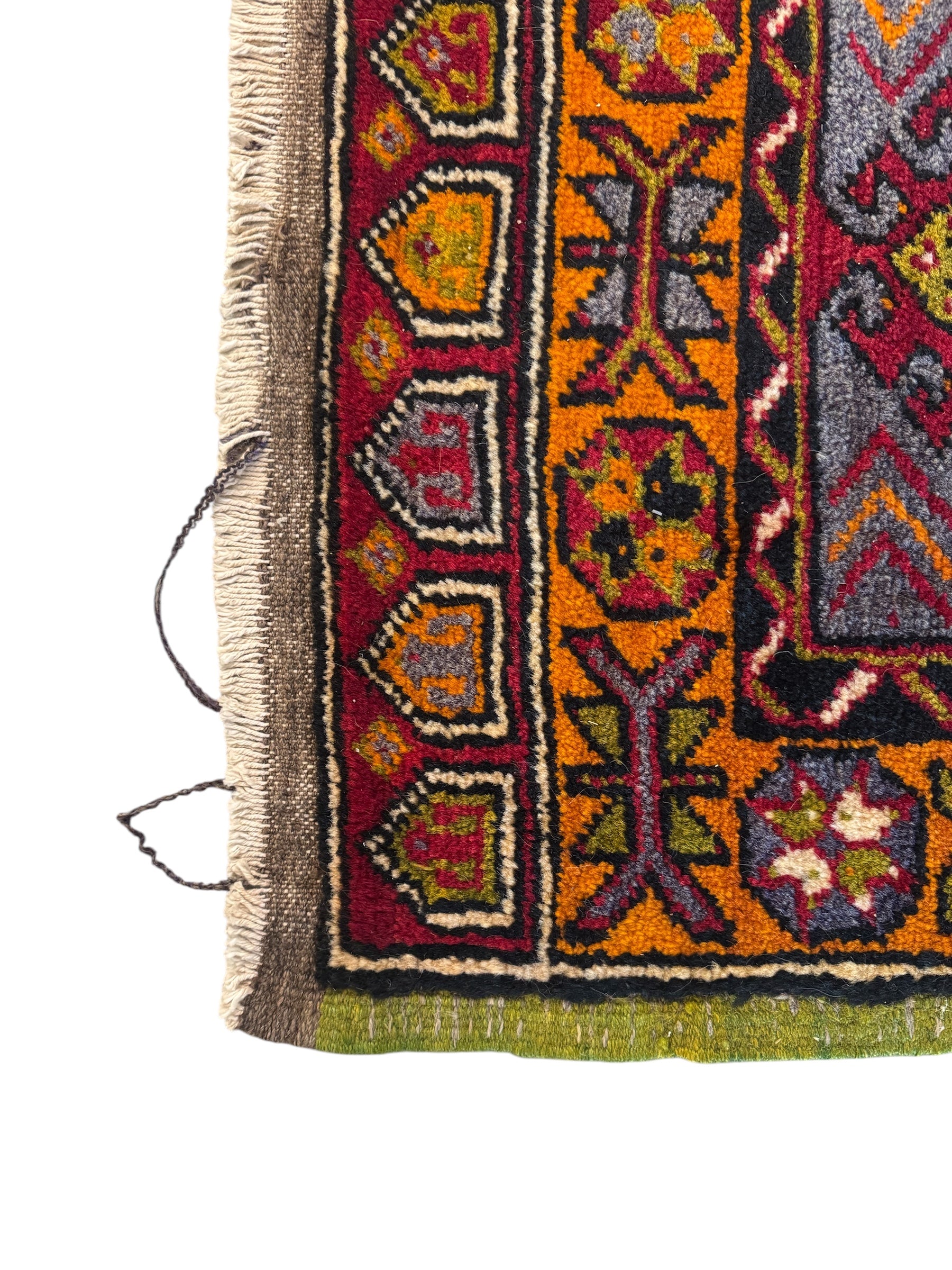 Anatolian Yastik rug with red, gold, green and gray geometric patterns and fringe.