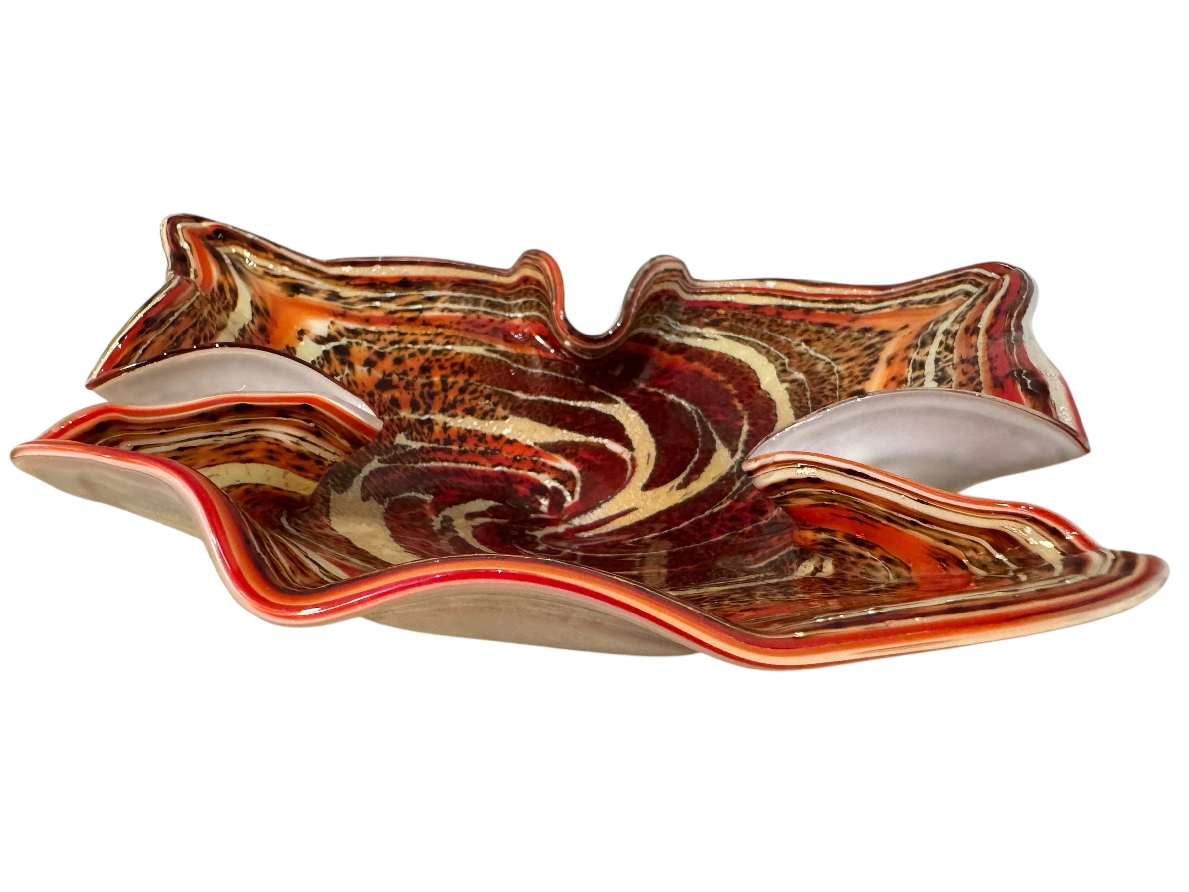 A Murano art glass bowl with a freeform shape, featuring layered swirls of brown, orange, and cream, accented with gold flecks. The bowl has a translucent white base.