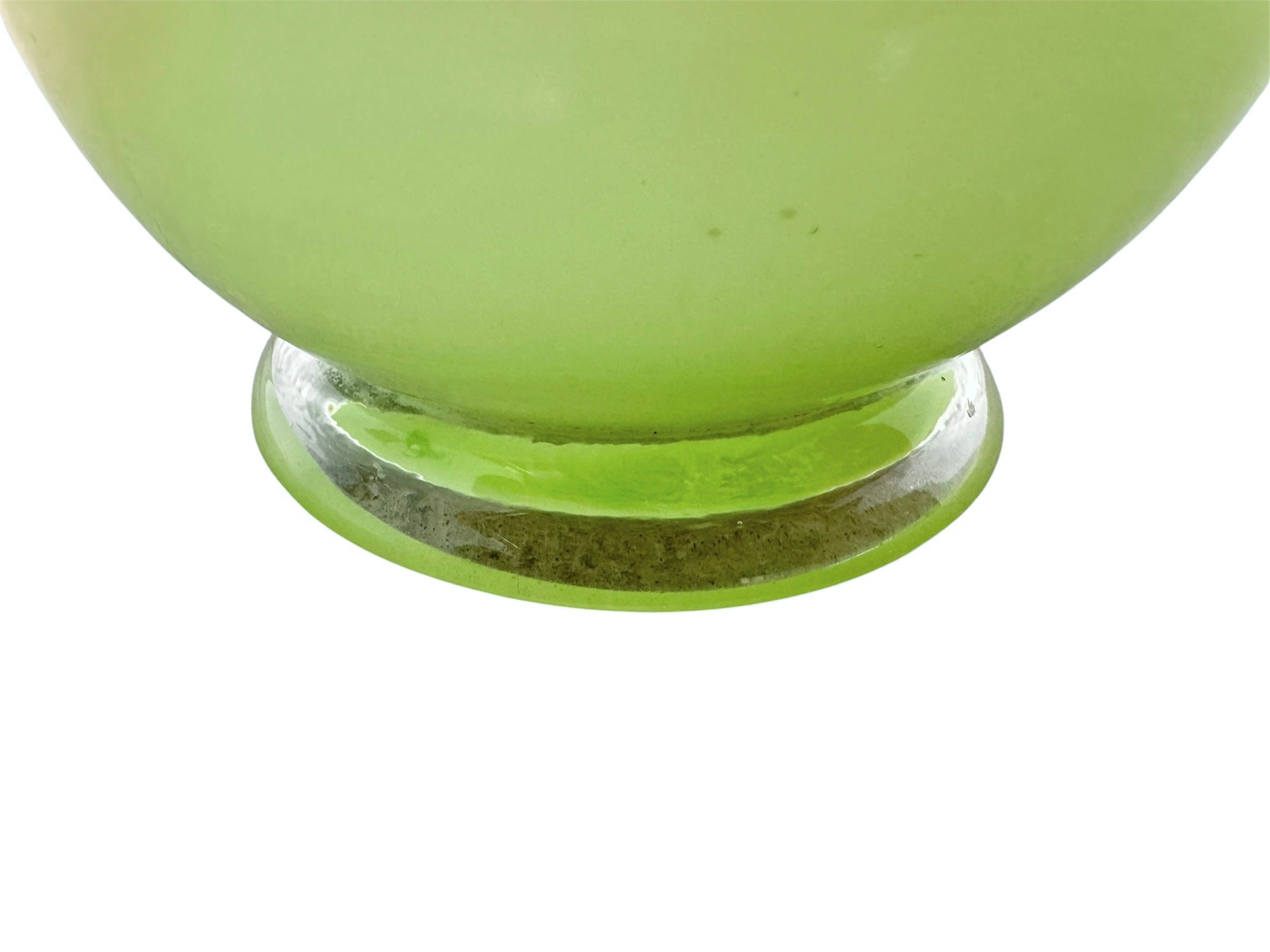 A mid-century modern, lime green cased-glass vase with a wide, flared rim and a thick, clear glass base. The exterior is a glossy chartreuse green, while the interior is lined with solid milk-white glass. The defining feature is a large, vertical oval cutout window that pierces directly through the center of the vase's body, creating an open-air negative space.