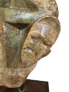 Figural sculpture in the Shona style, Zimbabwe. Two abstracted figures are intertwined, carved from greenish-brown soapstone. Sculpture rests on a dark iron stand.