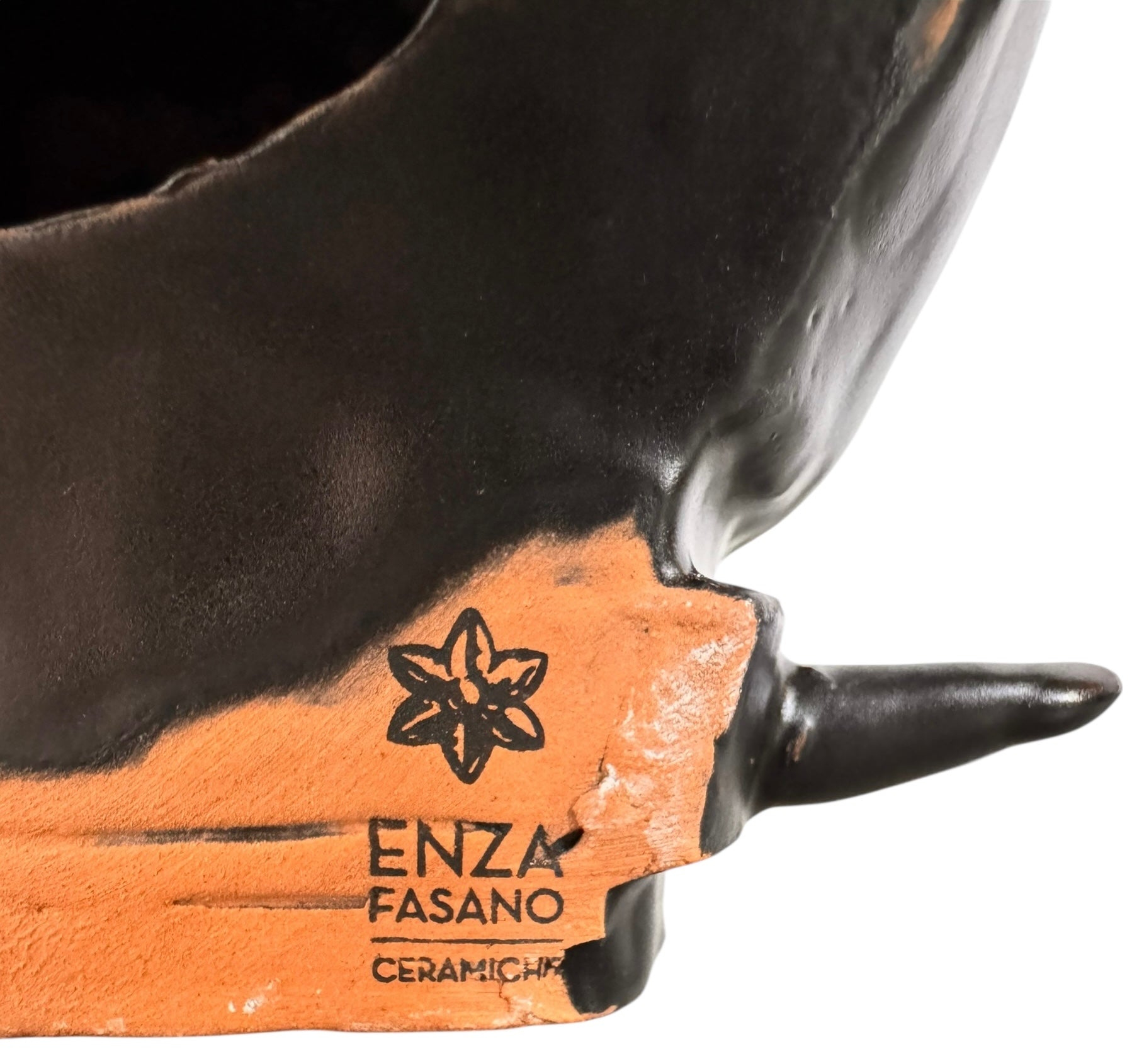 A smooth, dark black-colored ceramic sculpture of a Miniature Pinscher's head. The stylized dog features large, upright pointed ears and a prominent spiked collar around its neck. The surface has a soft sheen, with minimalist indentations for eyes and a rounded snout, creating a sleek and modern aesthetic.