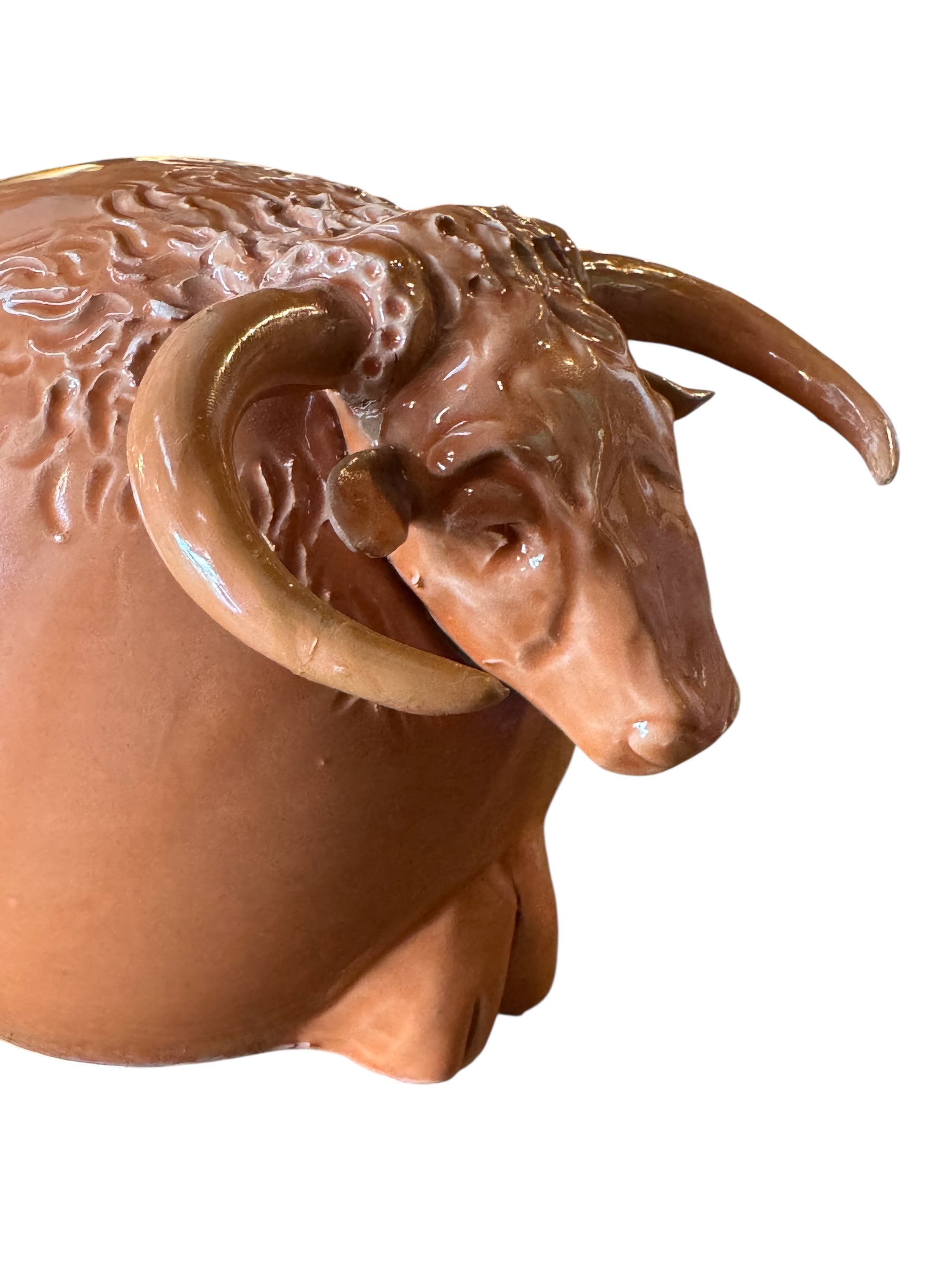 Terracotta colored ceramic Highland cow sculpture with a shaggy coat and curved horns