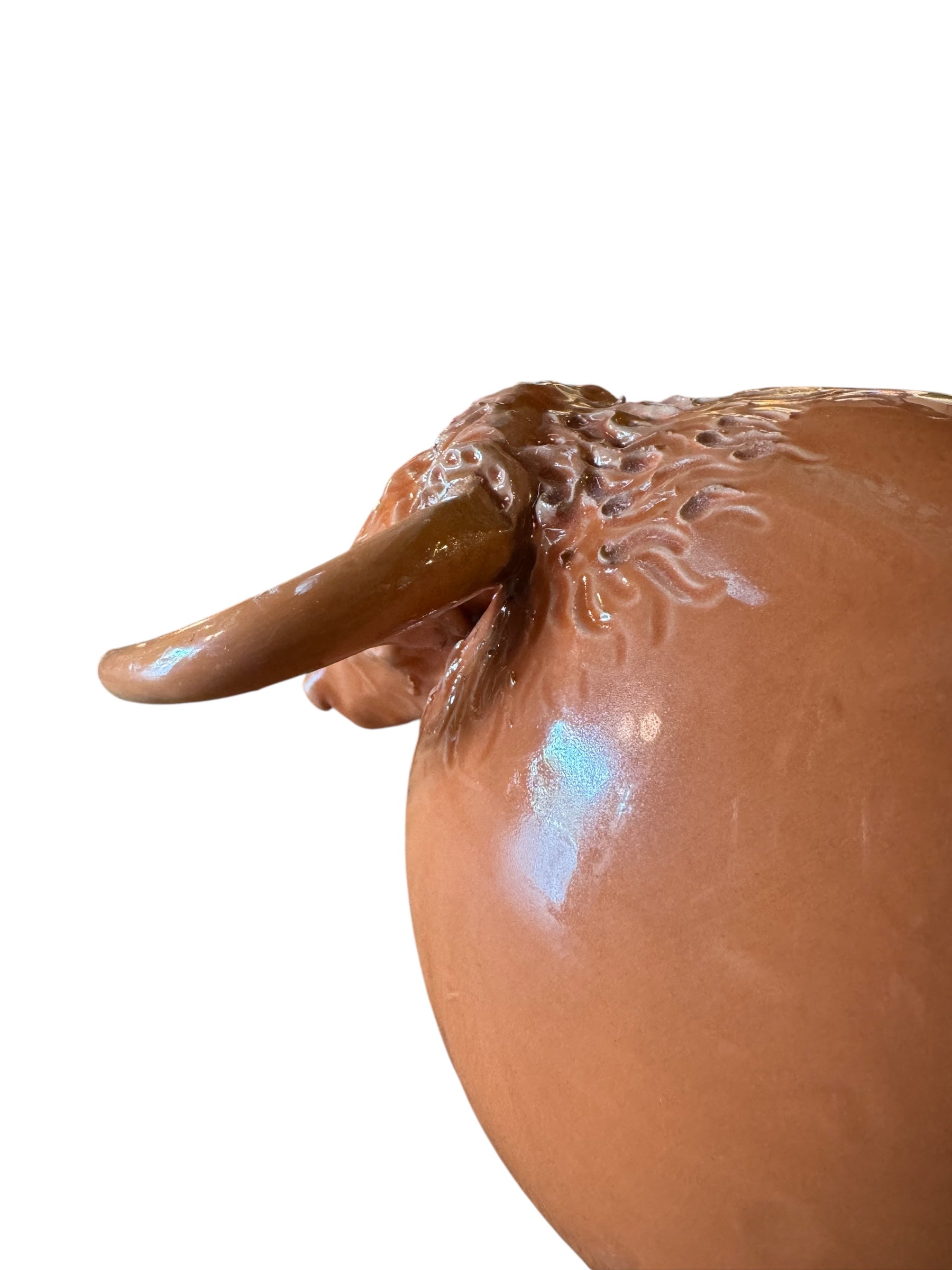 Terracotta colored ceramic Highland cow sculpture with a shaggy coat and curved horns