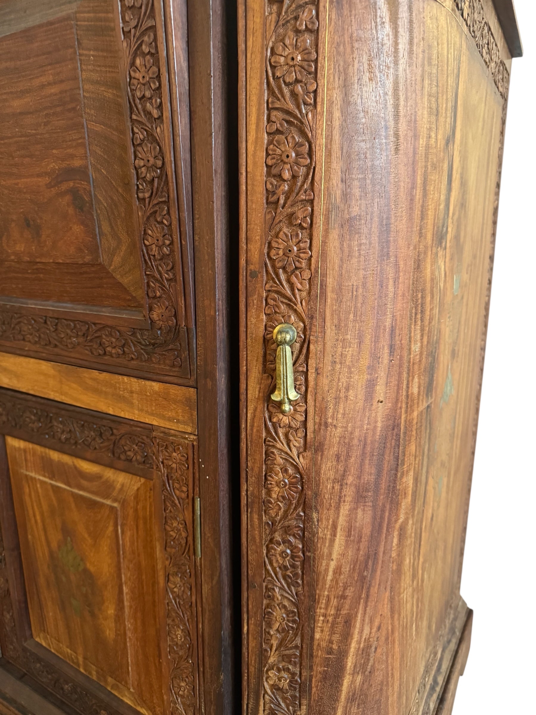 Antique bar cabinet with wood inlay and brass floral details, open to reveal interior shelving and bar storage