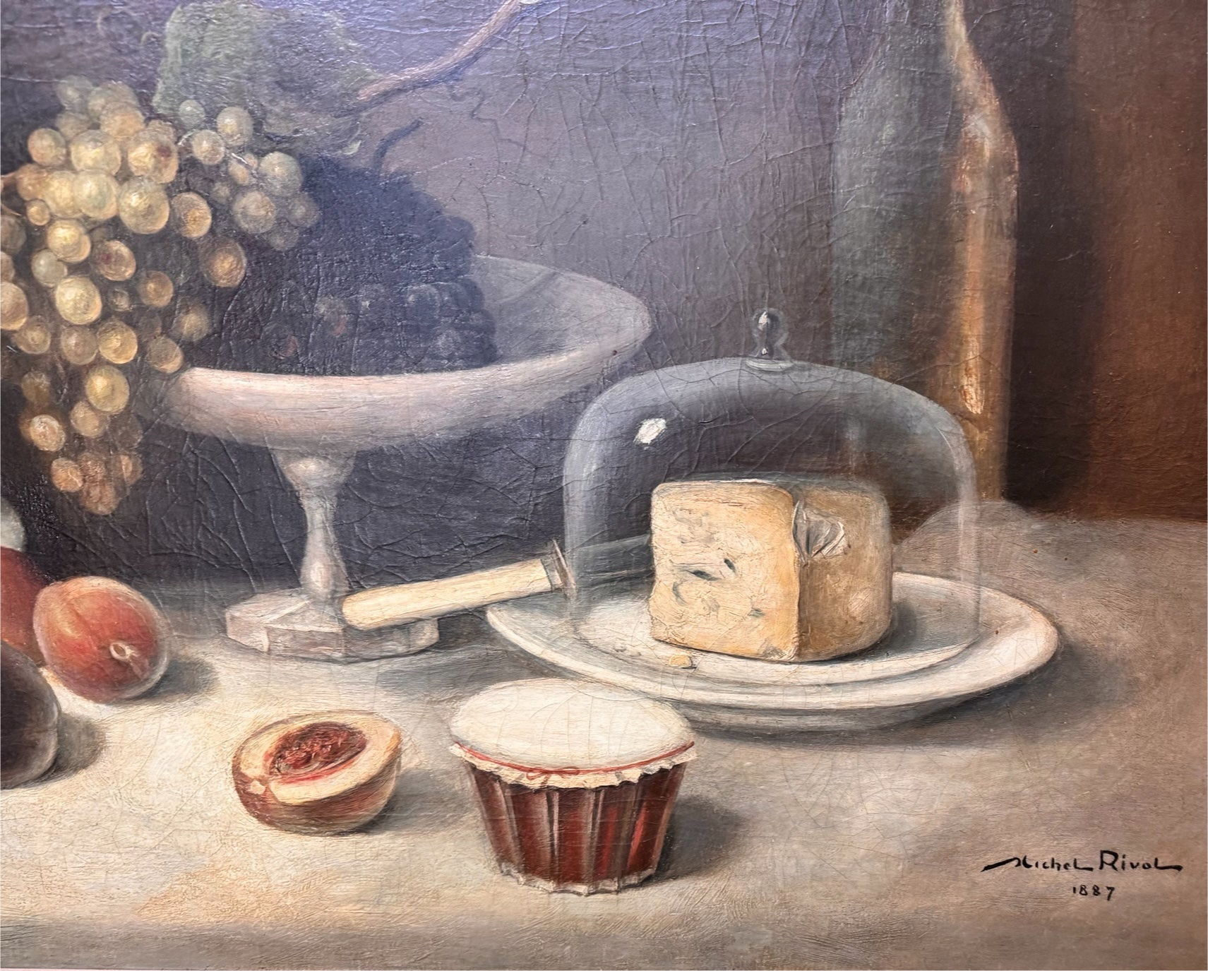 Oil painting, 'Still Life with Fruit and Cheese' by Michel Rivol, 1887. Features grapes, melons, cheese under a glass dome, and a bottle on a tablecloth against a dark background