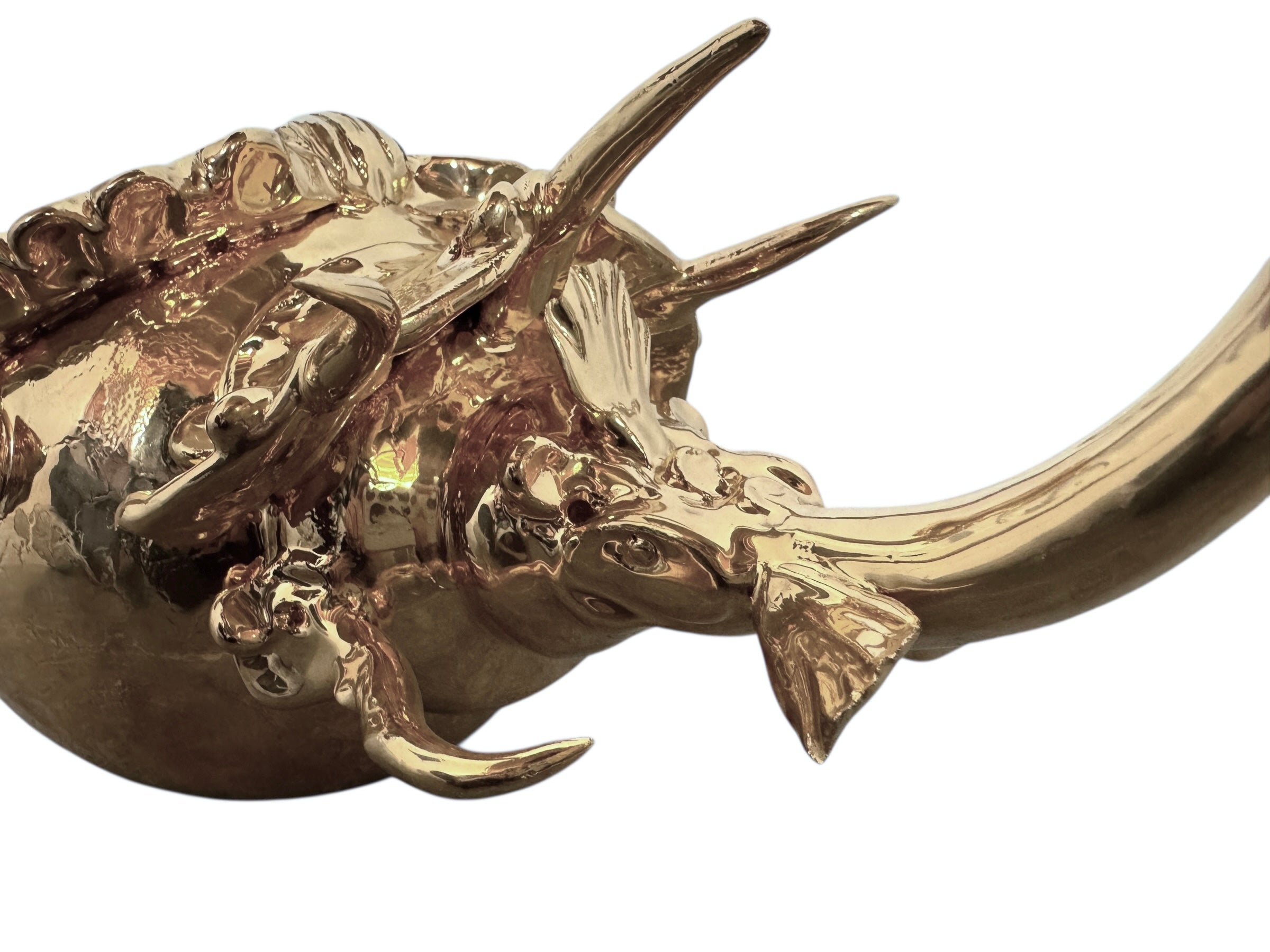 A handcrafted ceramic sculpture of a rhinoceros beetle by Enza Fasano, featuring a brilliant, high-gloss gold metallic finish. The beetle is captured in a dynamic, slightly upturned pose with detailed textures on its ribbed shell and prominent, curved horns. The piece reflects light across its polished surface, showcasing the artist’s signature fusion of traditional Pugliese pottery and contemporary luxury.