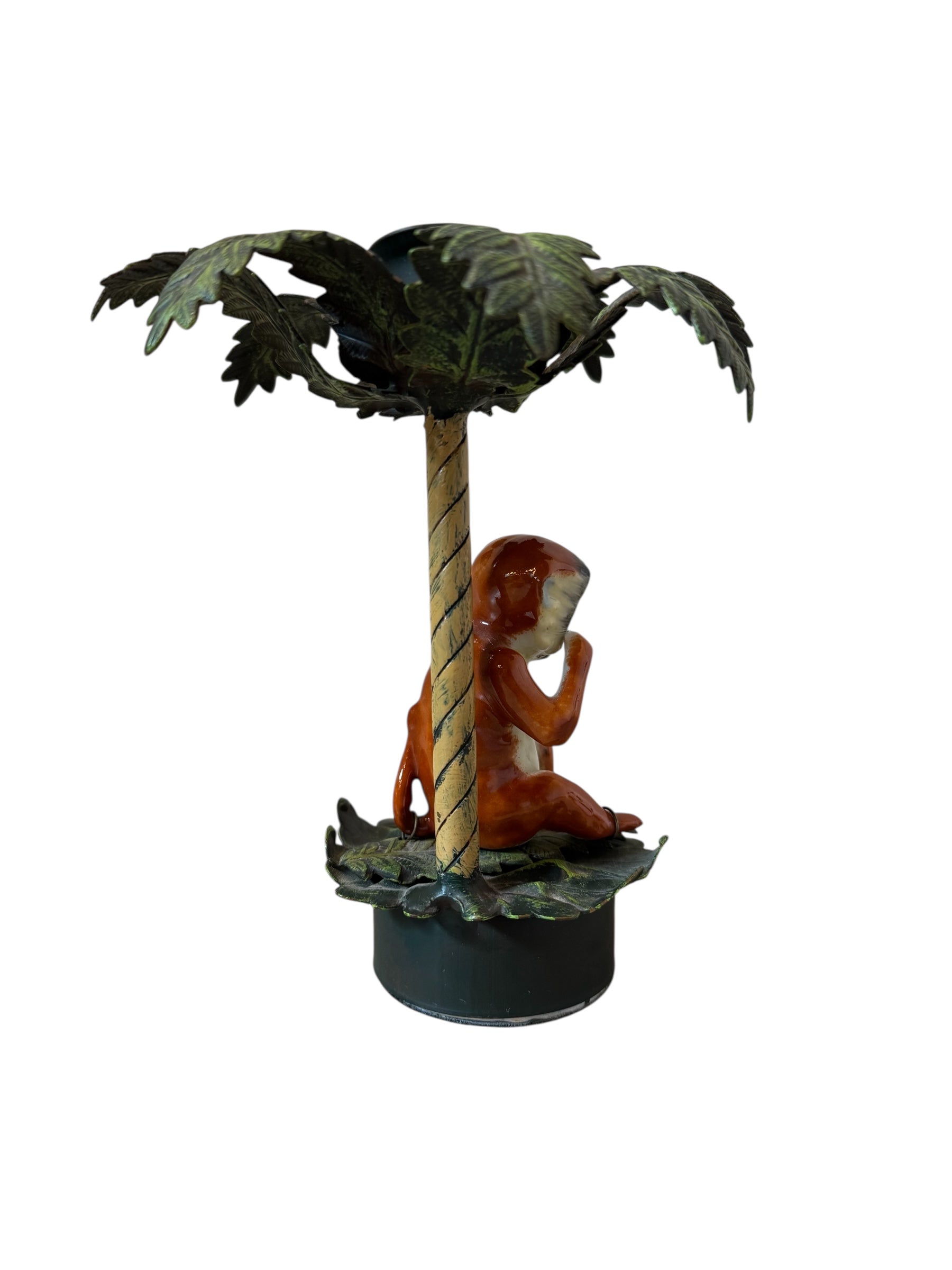 Statue of a figure sitting under a palm tree on a white background