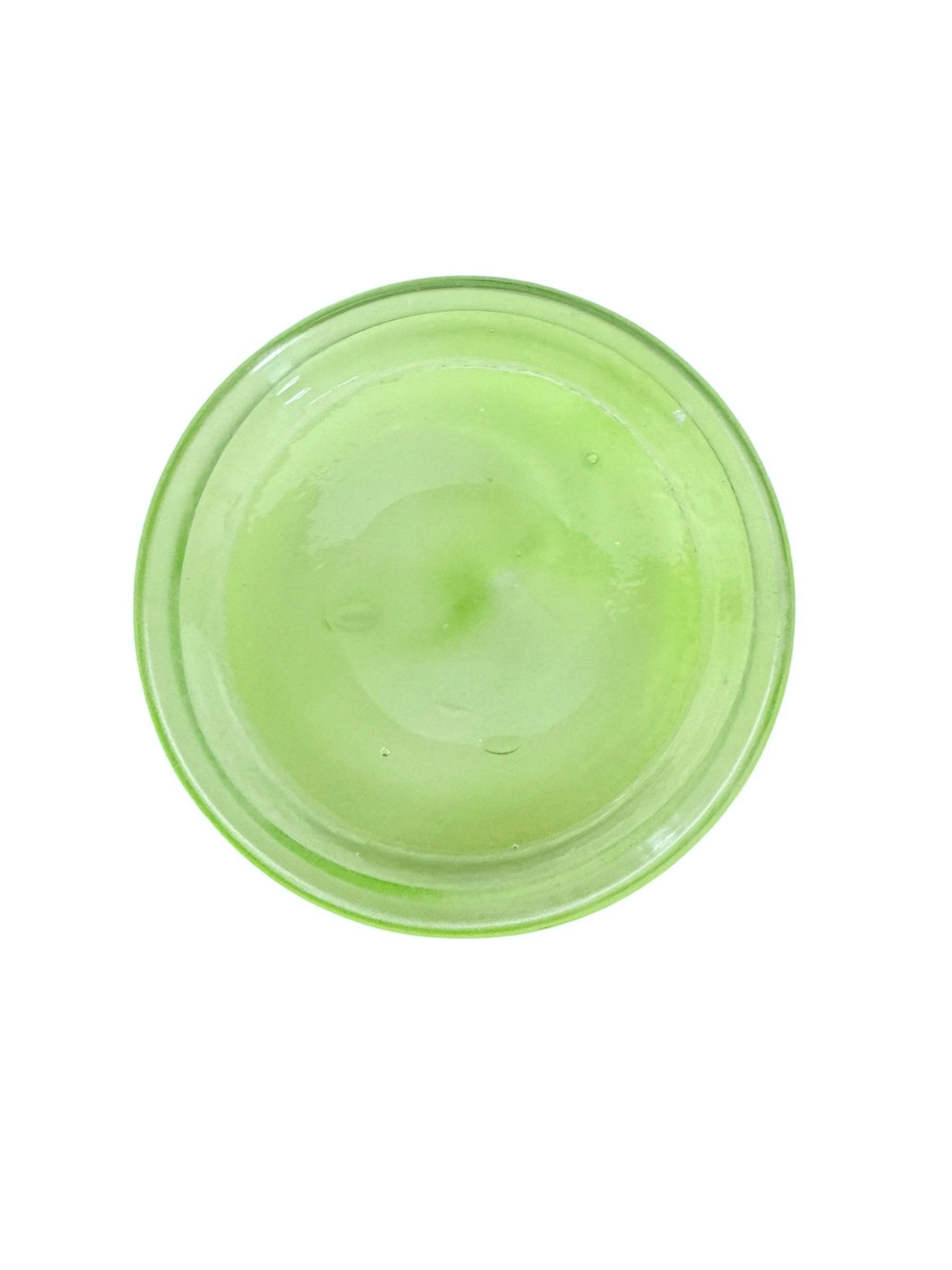 A mid-century modern, lime green cased-glass vase with a wide, flared rim and a thick, clear glass base. The exterior is a glossy chartreuse green, while the interior is lined with solid milk-white glass. The defining feature is a large, vertical oval cutout window that pierces directly through the center of the vase's body, creating an open-air negative space.