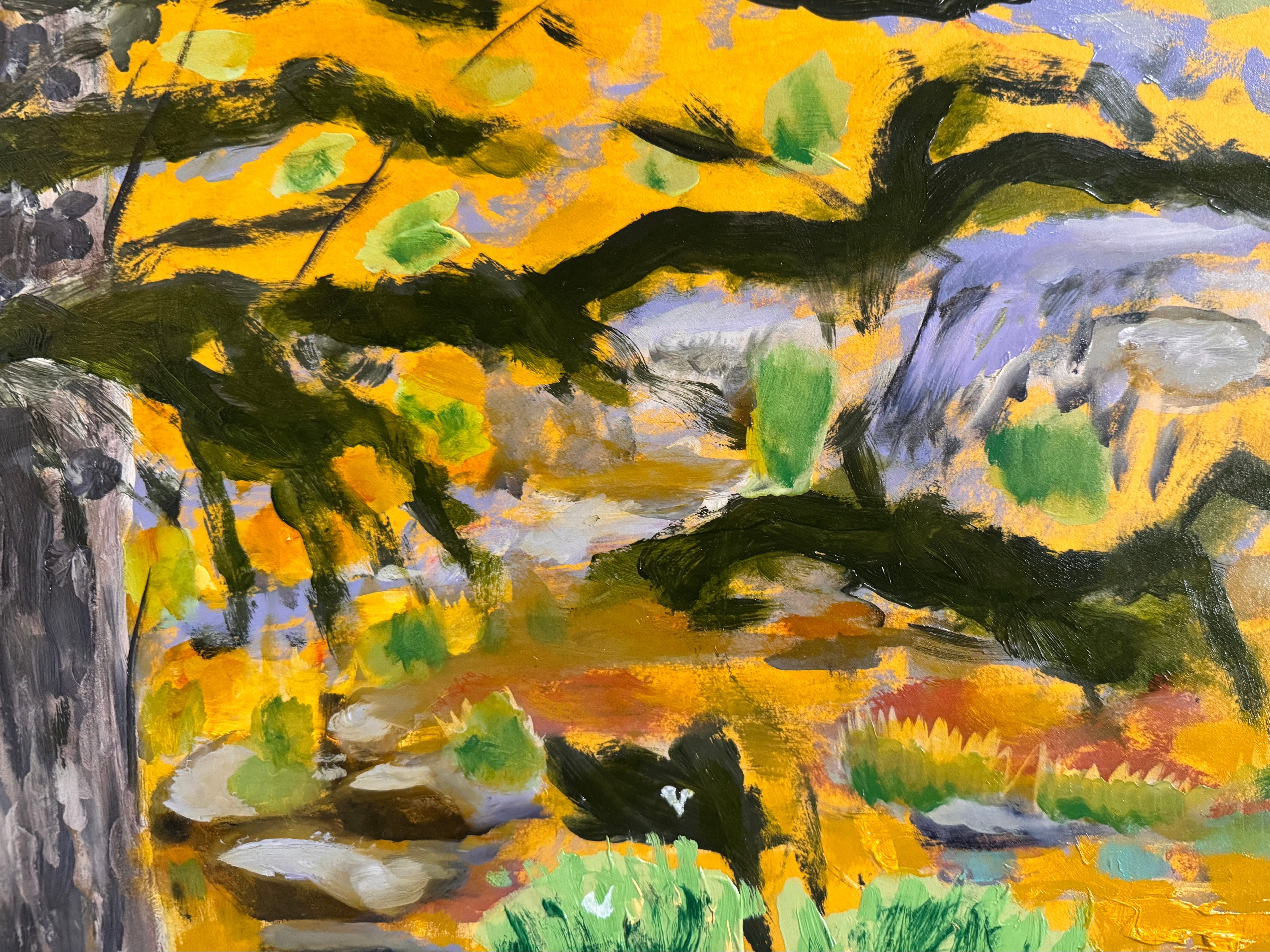 A vibrantly colored landscape painting titled 'Perdernales Falls Fisherman,' featuring two large trees with prominent exposed roots framing a body of water. A lone figure, a fisherman, stands by the water in the middle ground. The painting uses bold strokes of yellow, green, red, and blue, and is enclosed in a rustic dark wooden frame with a light-colored inner mat.