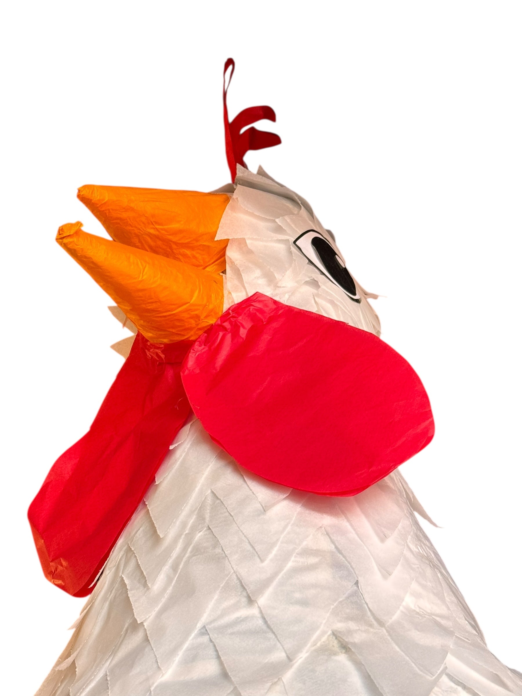 A white chicken pinata with red comb and wattles, and orange beak and legs, standing upright.