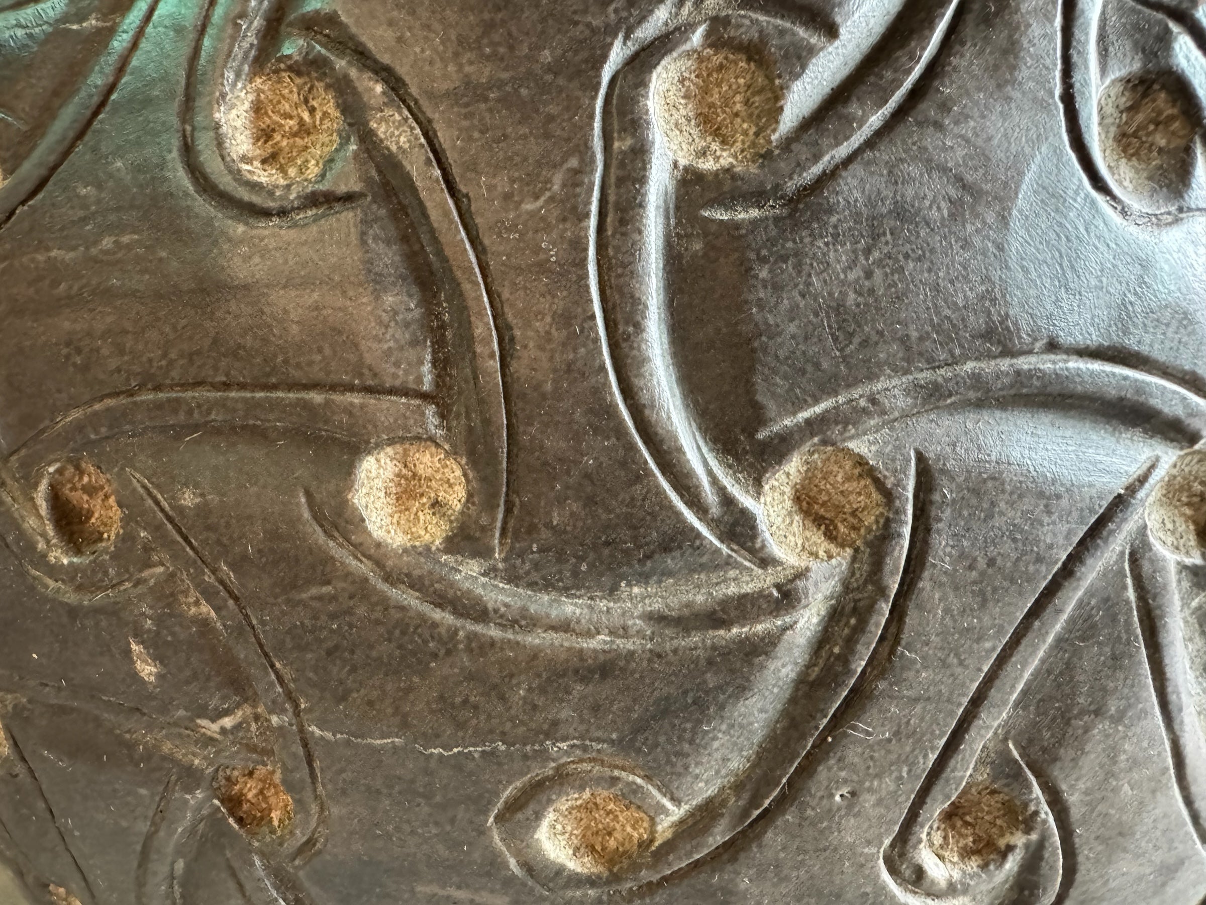 A heavy stone planter, featuring an intricate, hand-carved pattern resembling Celtic knot work.