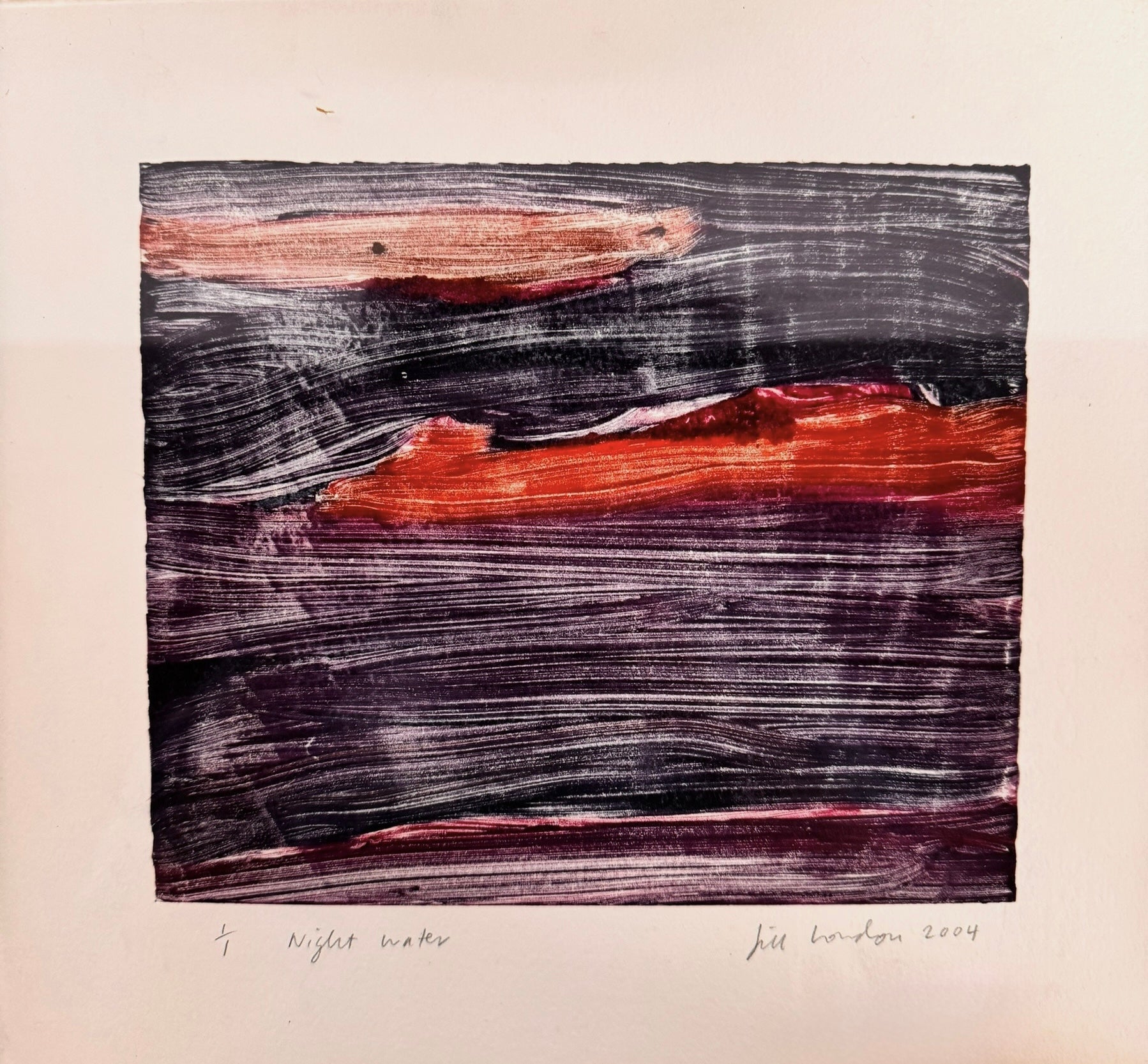 A horizontal, rectangular abstract print titled "Night Water" centered within a white mat and a thin gold frame. The artwork features dense, textured horizontal brushstrokes in deep shades of violet, indigo, and black. A prominent, gestural streak of vibrant red and a softer blush-pink band cut across the dark "water," suggesting a sunset reflection or light hitting a dark surface. The artist's signature, title, and the year 2004 are visible in pencil at the bottom.