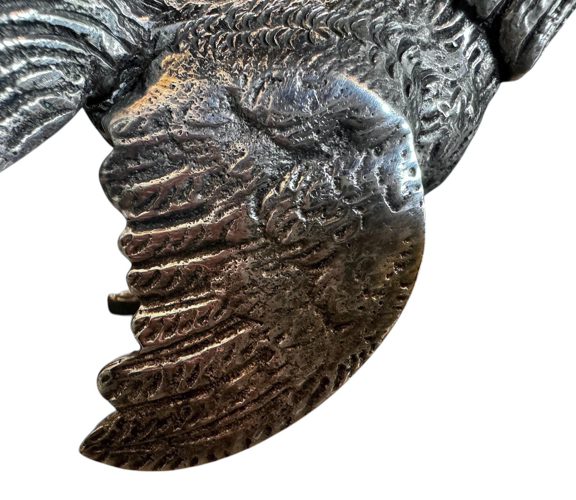 A pair of vintage, silver-plated brass fighting rooster figurines positioned in a confrontational stance against a white background. The rooster on the left is crouched low with its head down and tail feathers fanned high, while the rooster on the right stands more upright with its wings slightly flared. Both feature intricate feather detailing, a metallic patina showing hints of brass through the silver, and small, bright red glass eyes.