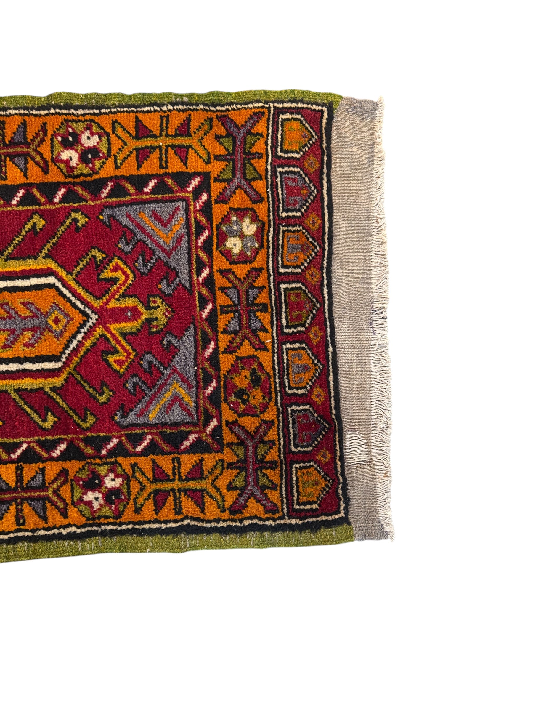 Anatolian Yastik rug with red, gold, green and gray geometric patterns and fringe.