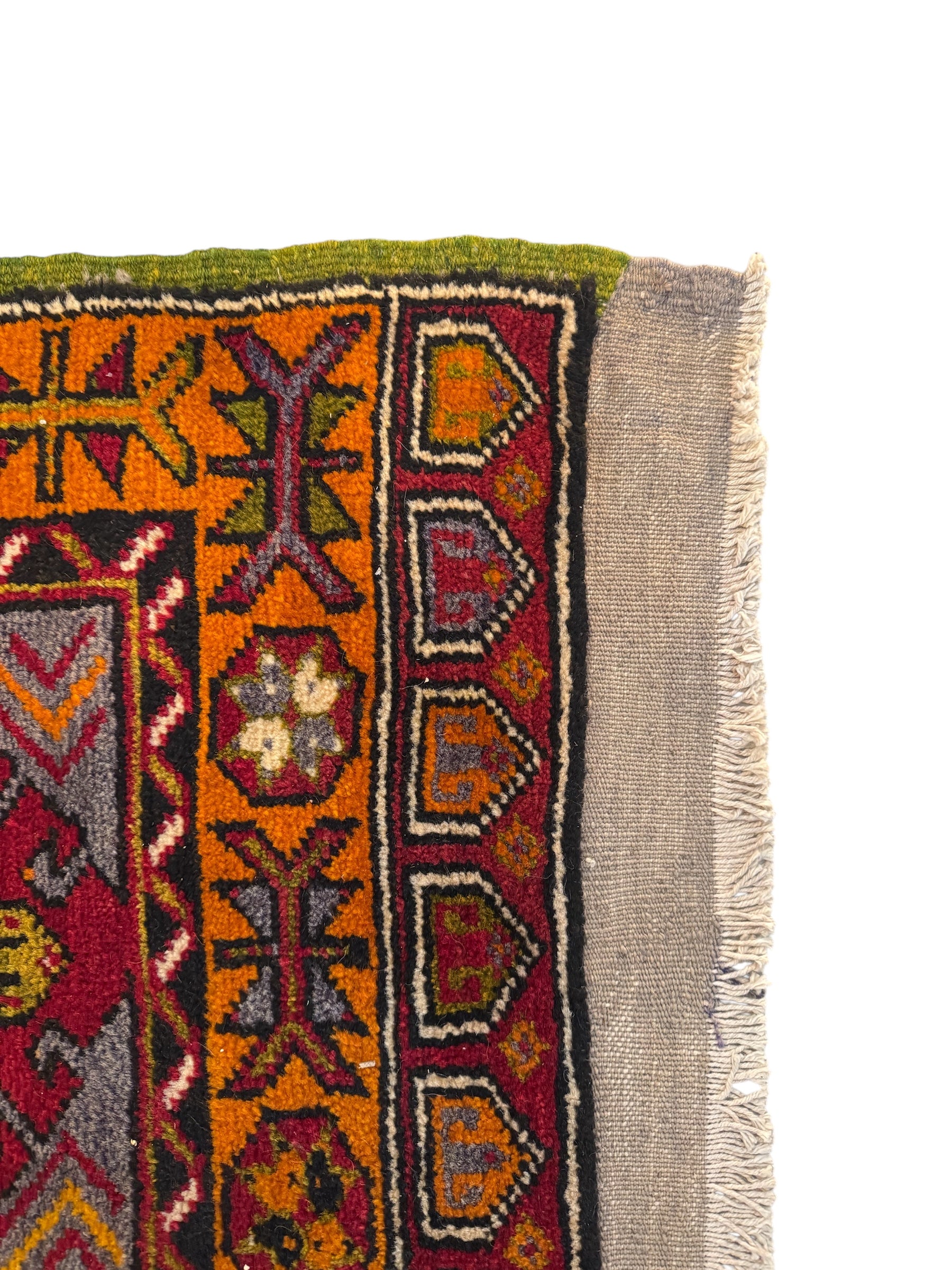 Anatolian Yastik rug with red, gold, green and gray geometric patterns and fringe.