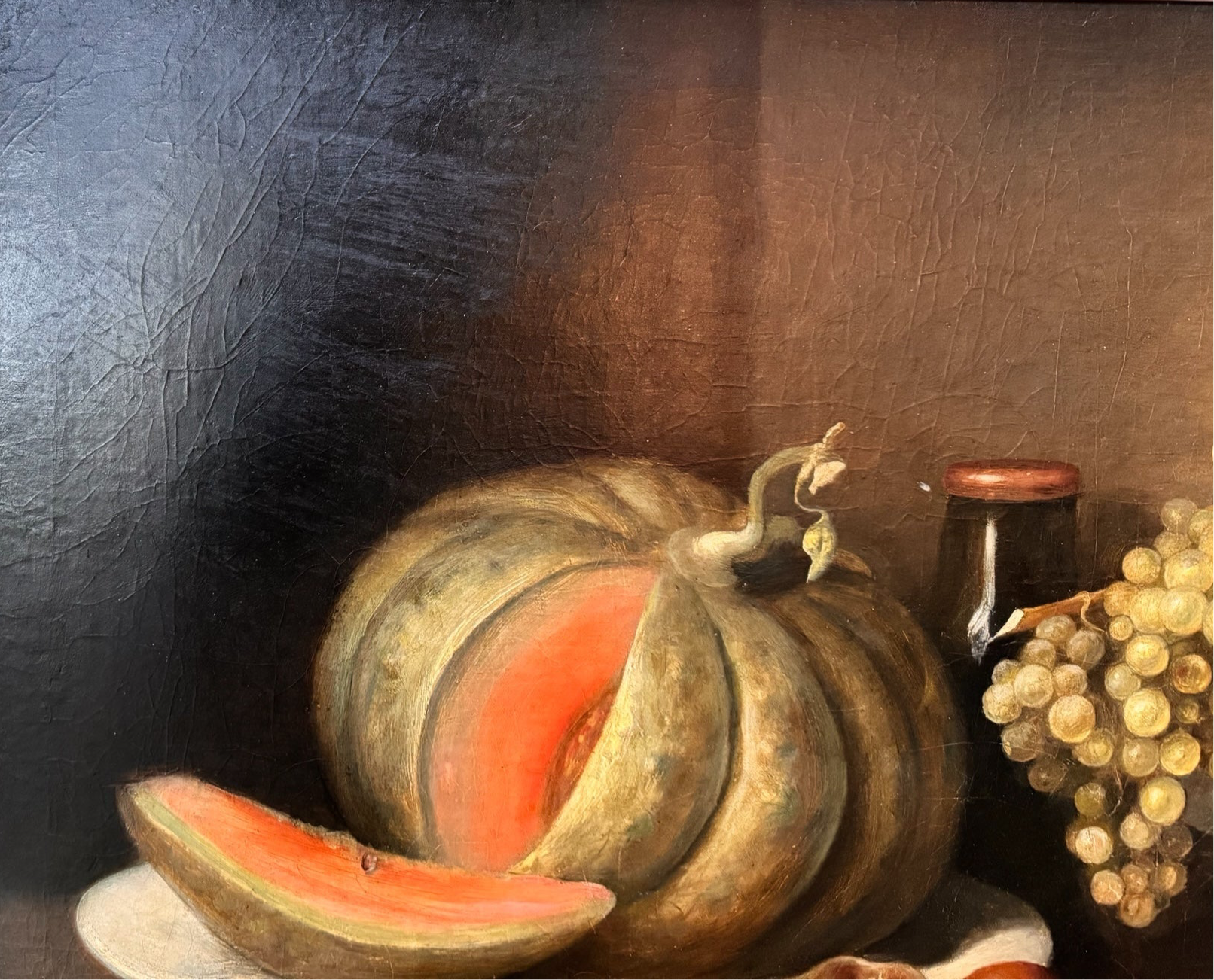 Oil painting, 'Still Life with Fruit and Cheese' by Michel Rivol, 1887. Features grapes, melons, cheese under a glass dome, and a bottle on a tablecloth against a dark background