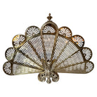 Antique brass peacock fan fire screen with intricate pierced details and a griffin base.