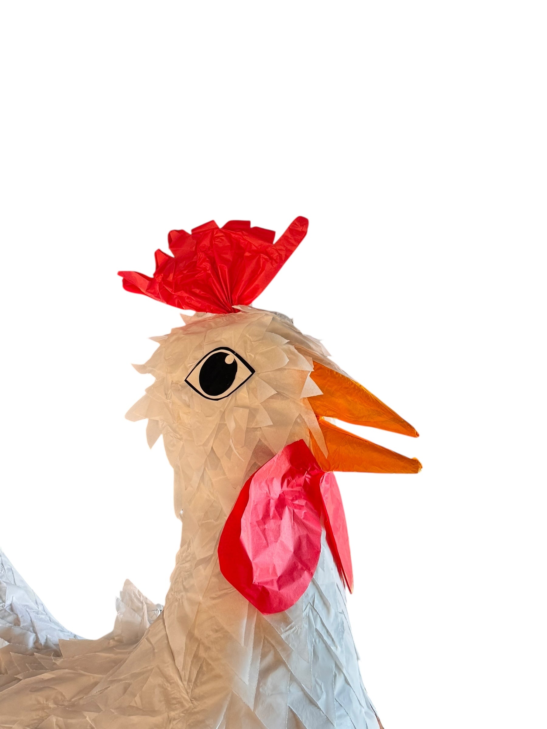 A white chicken pinata with red comb and wattles, and orange beak and legs, standing upright.