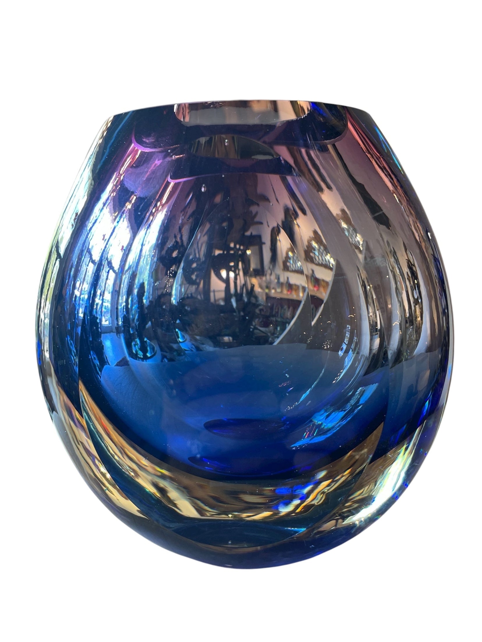 Sommerso glass vase with flattened sides creating a fish-eye effect, featuring cobalt and indigo colors and internal bubbles.