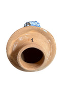 Handcrafted ceramic sculpture in the shape of a foot, decorated with intricate black and white patterns, 24KT gold accents, and topped with a blue lid featuring a gilt fish and head emerging from stylized waves.