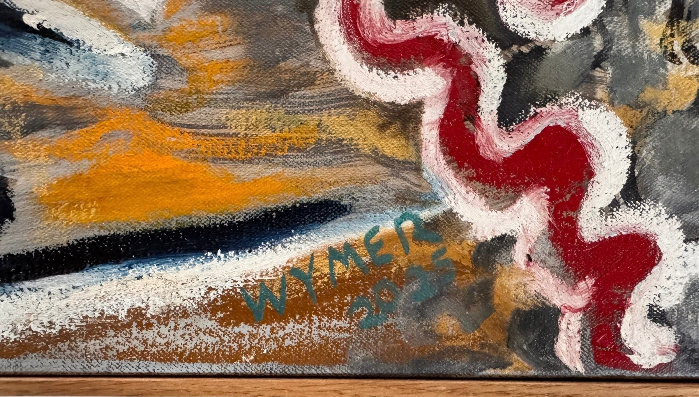 A close-up, angled view of an abstract oil painting titled 'Topography' by Robert Wymer. The painting's edge reveals thick, textured swirls of brown, gold, red, green, and white paint. It is framed in a natural light-brown teak wood frame, with a visible corner joint where two pieces of wood meet