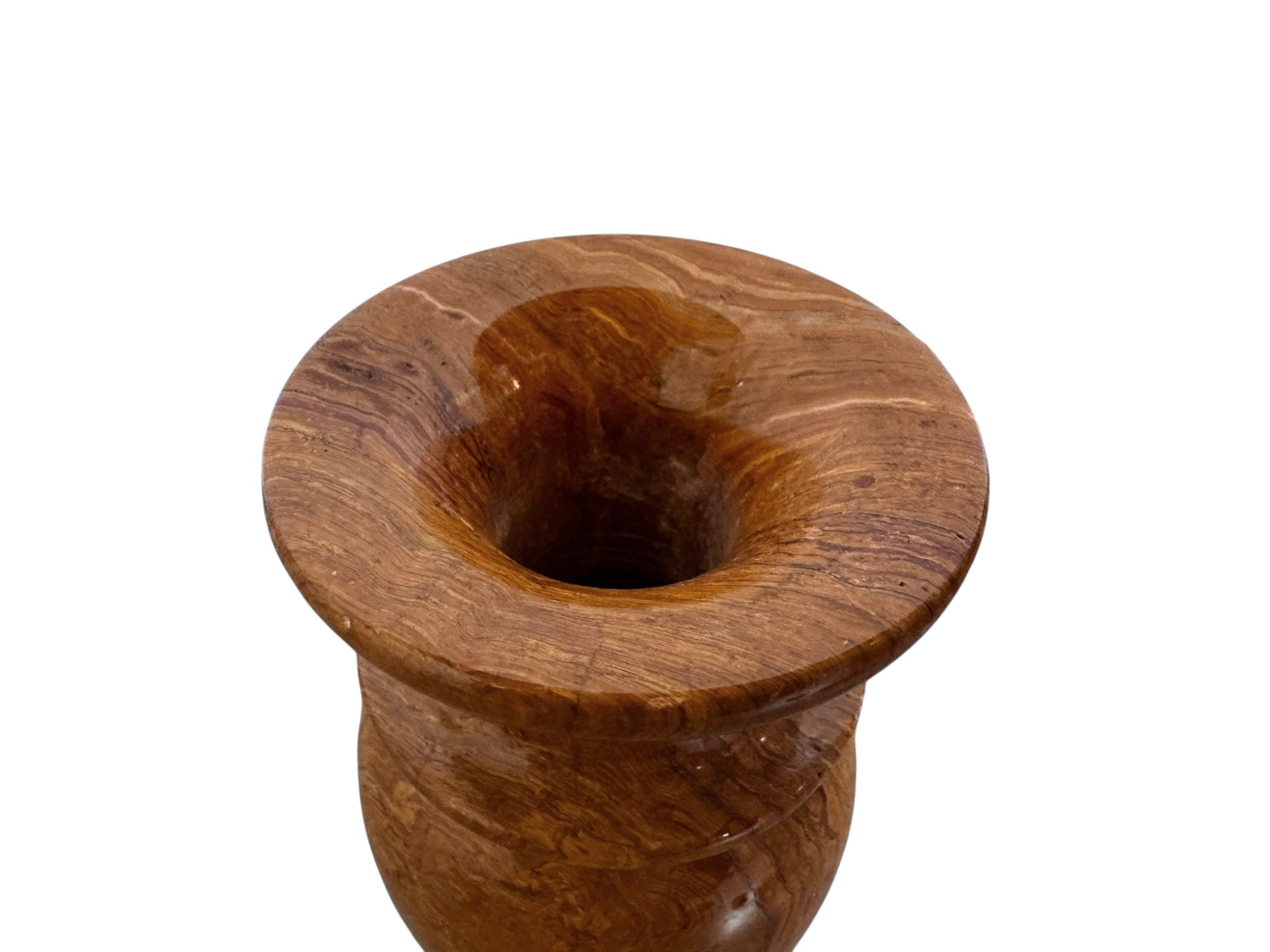 An elegant, hand-carved decorative vase made of polished Pakistani brown onyx. The vase features a classic, rounded urn shape with a tiered, flared neck and a solid matching spherical stone stopper resting on top. The stone displays rich, natural horizontal banding and swirling patterns in shades of honey, deep amber, rust-red, and cream. It stands on a small, integrated pedestal base against a clean white background, reflecting a high-gloss, mirror-like finish.