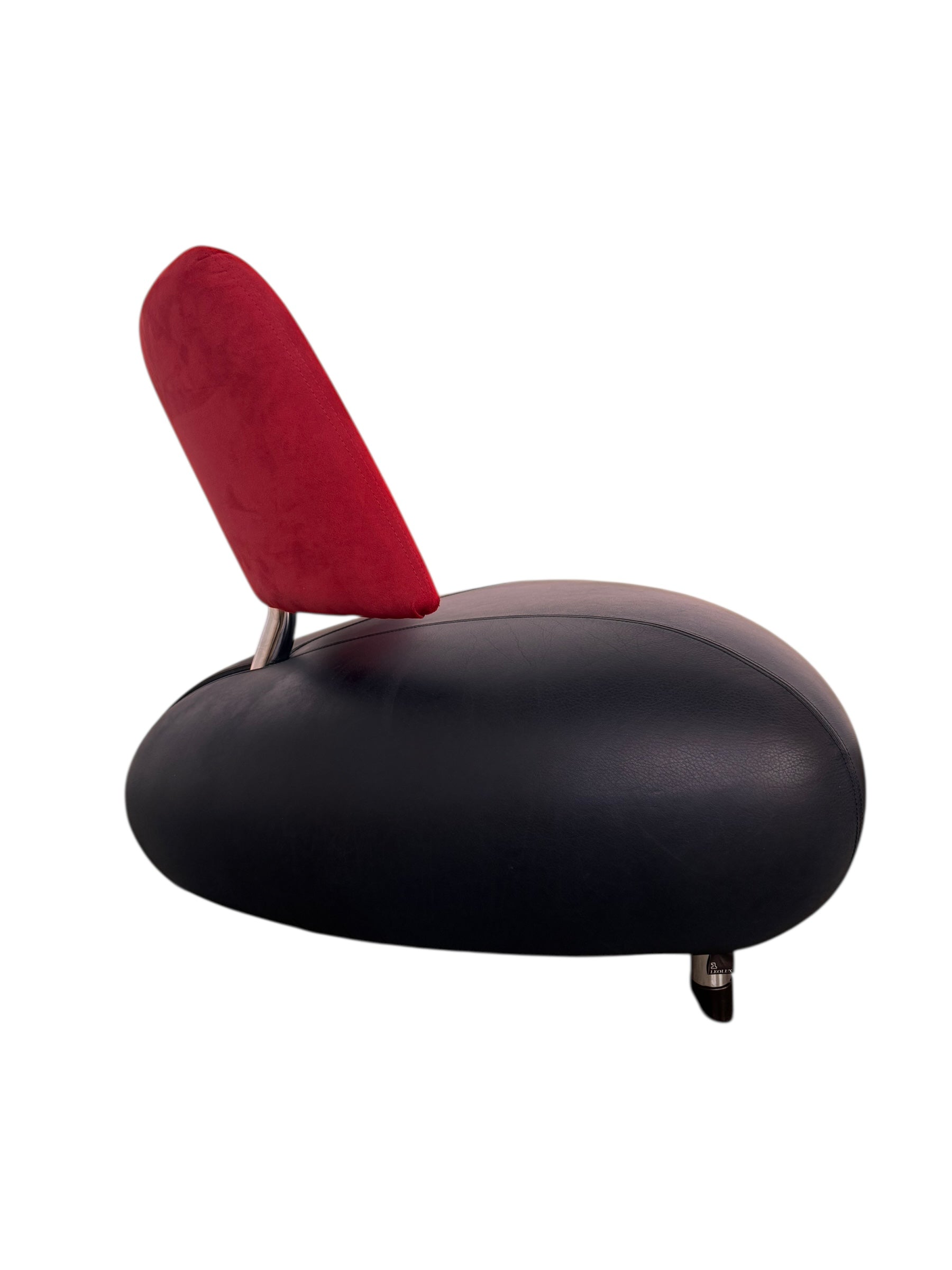 A Leolux Pallone armchair with a large, black, spherical leather seat and a smaller, red, curved leather backrest, supported by short metal legs.